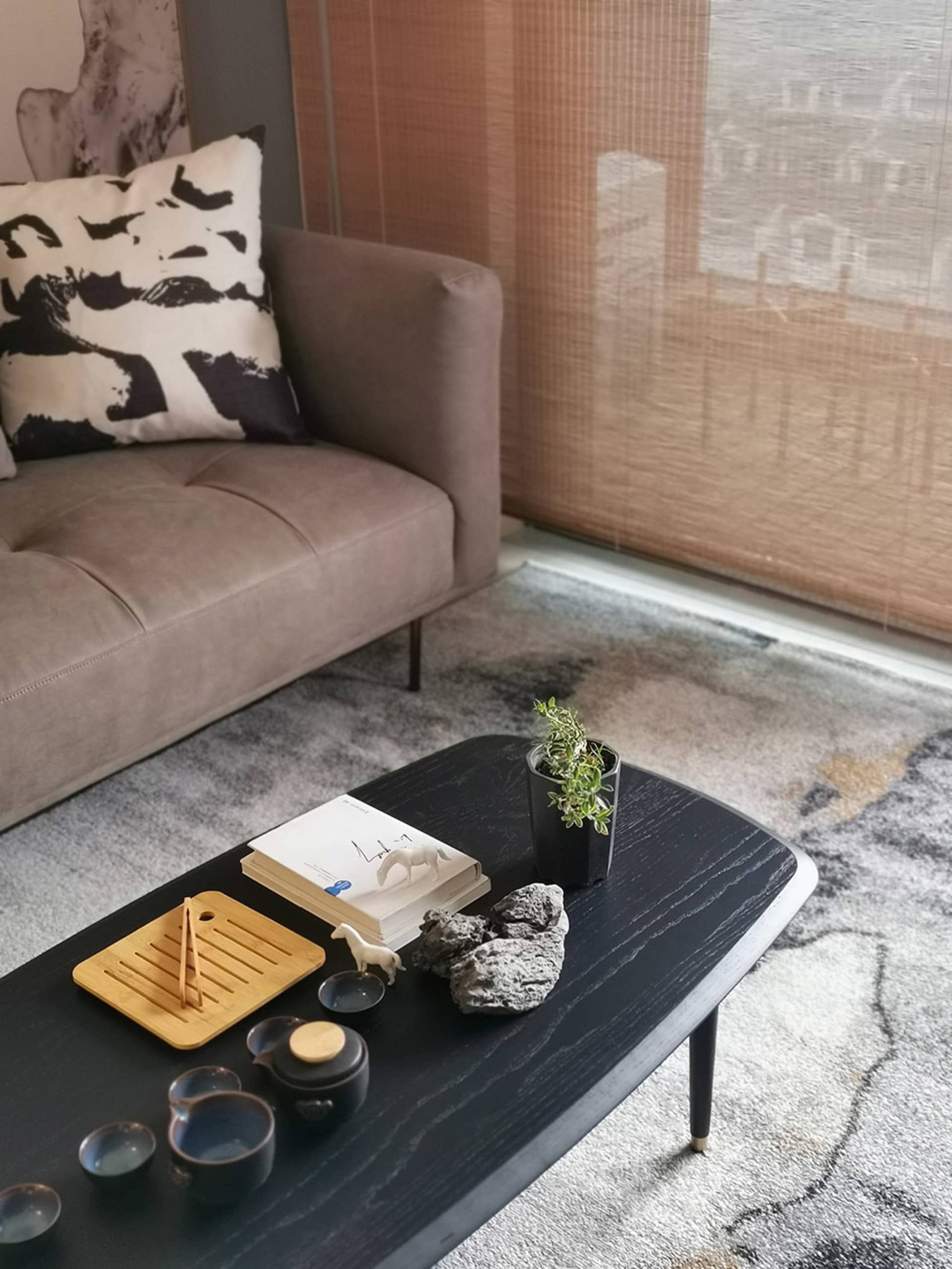 Tea set and cushions on a textured living room wall with blinds and cushions