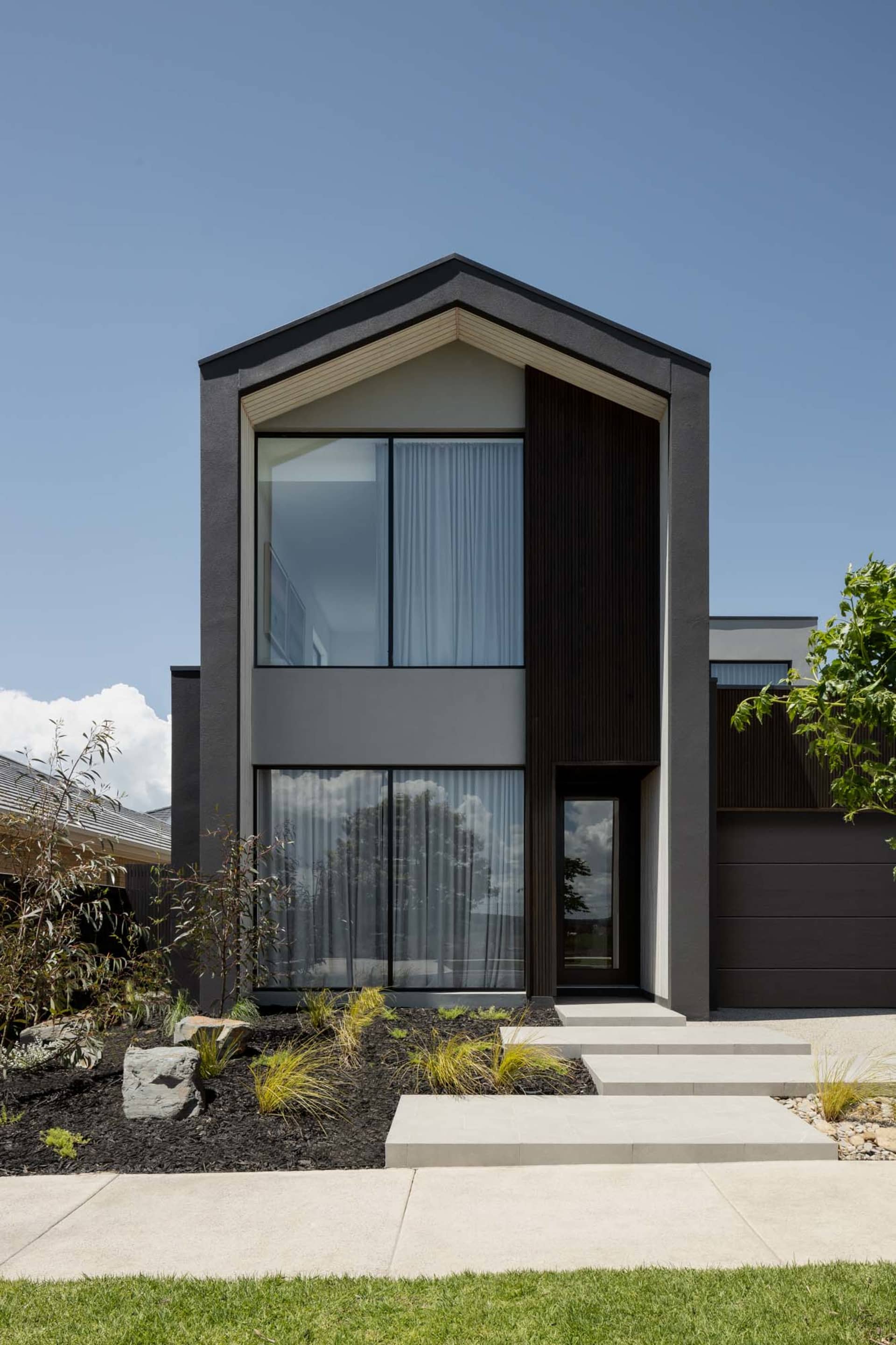 A modern house exterior with concrete, glass, and metal materials.