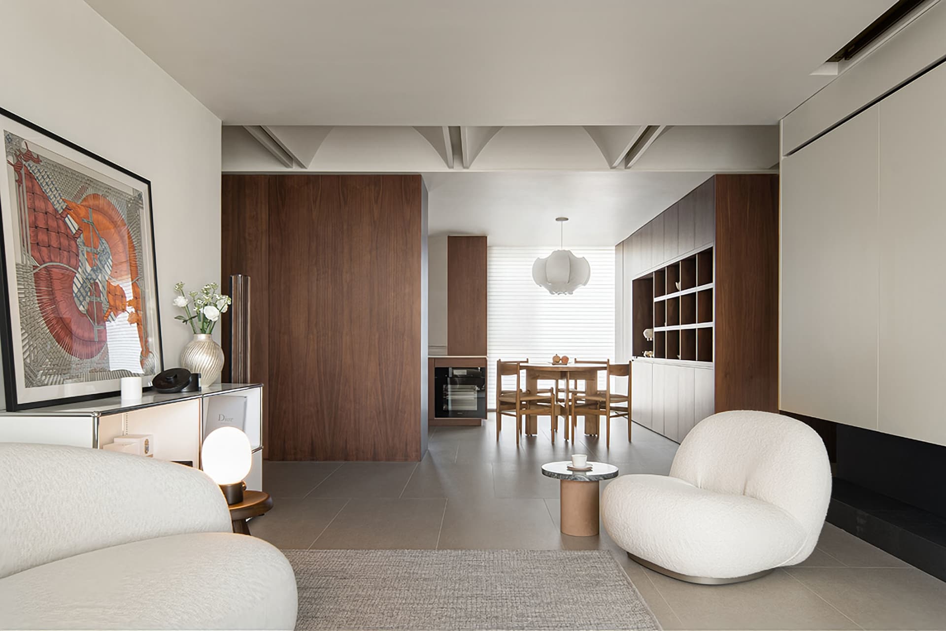 A modern living room with wooden furniture and a marble floor, featuring a round coffee table and a white sofa.