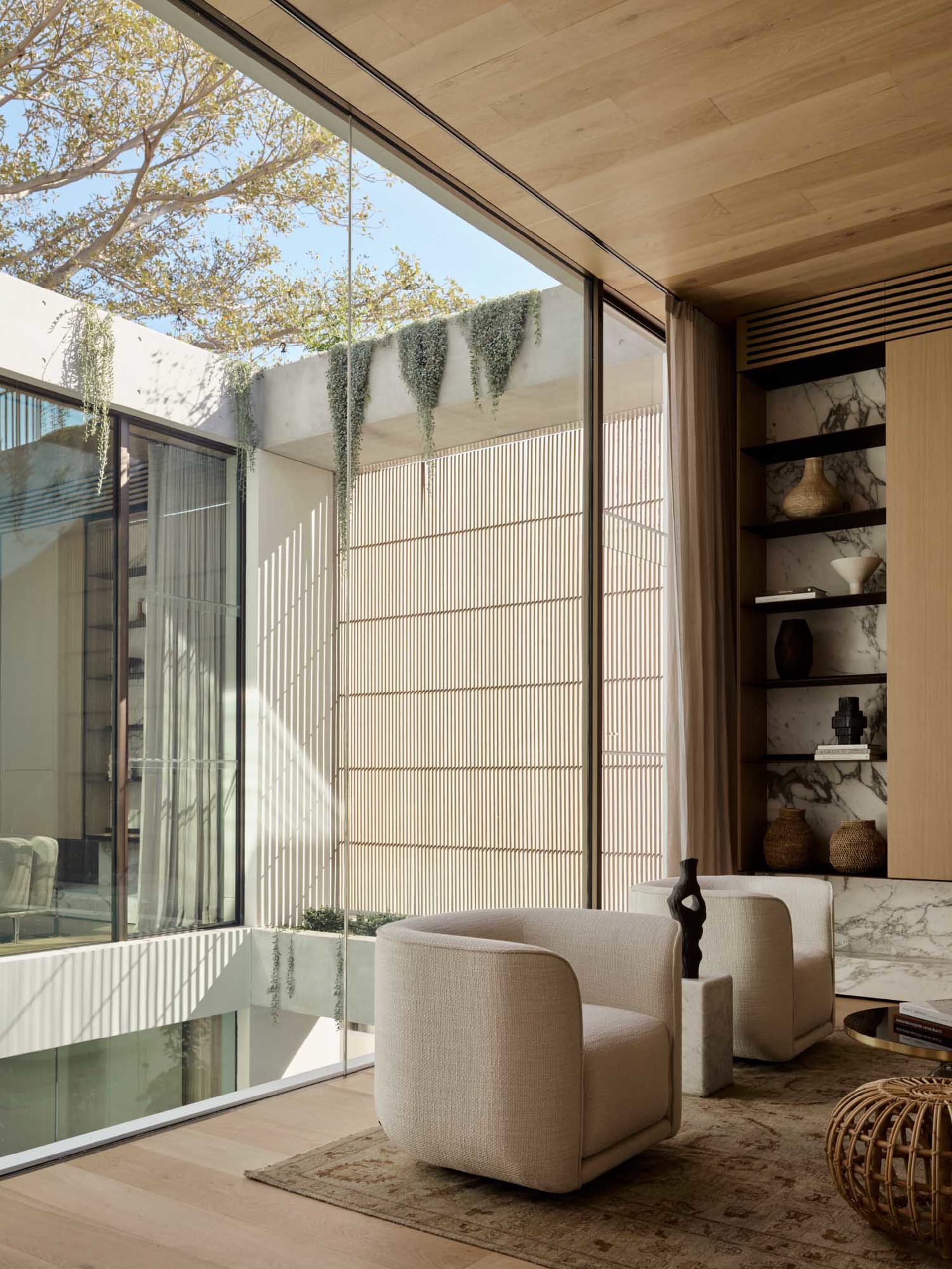 Modern interior design featuring a living room with marble walls and wood flooring.