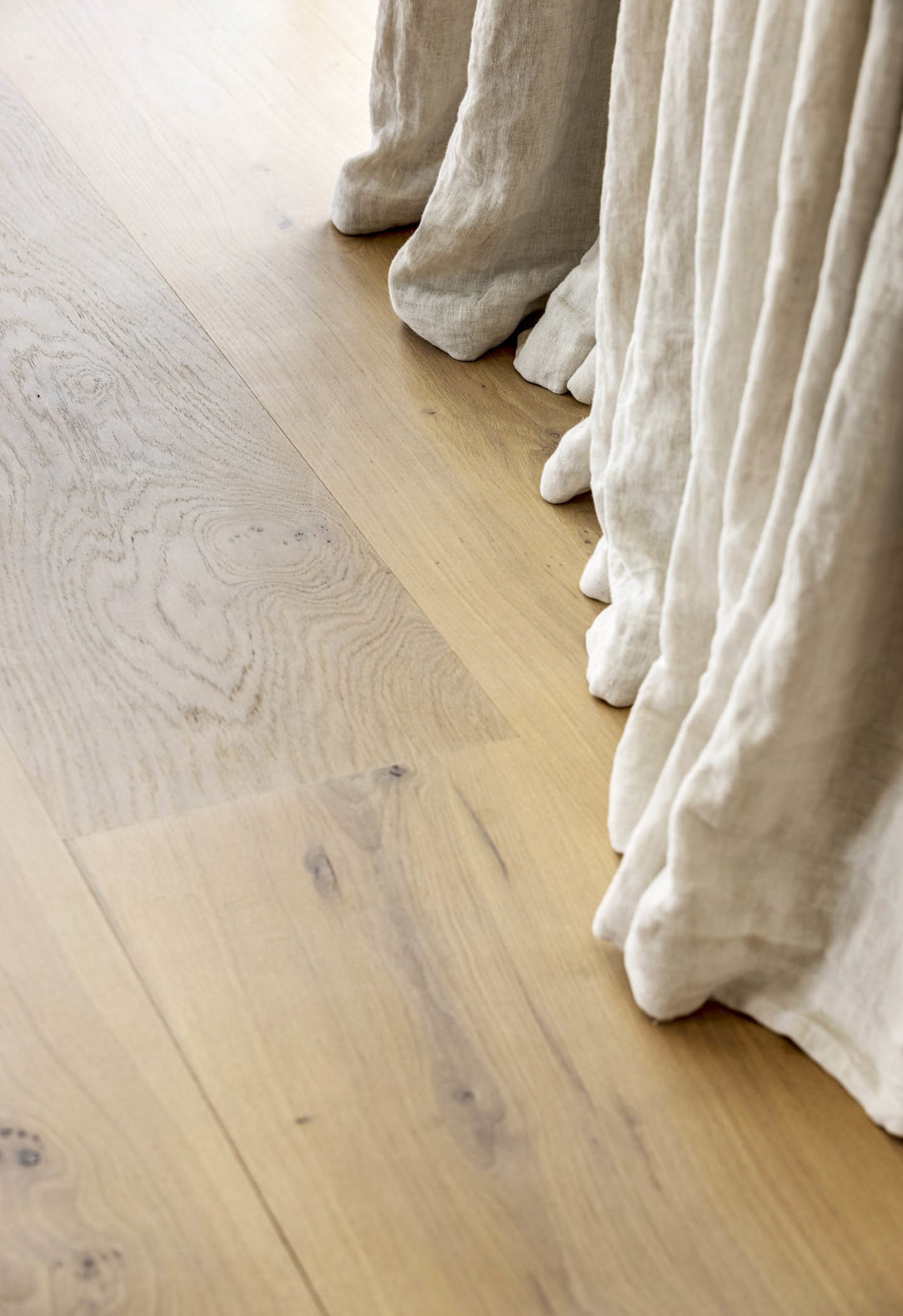 Close-up photo of white modern tiles on a wooden floor