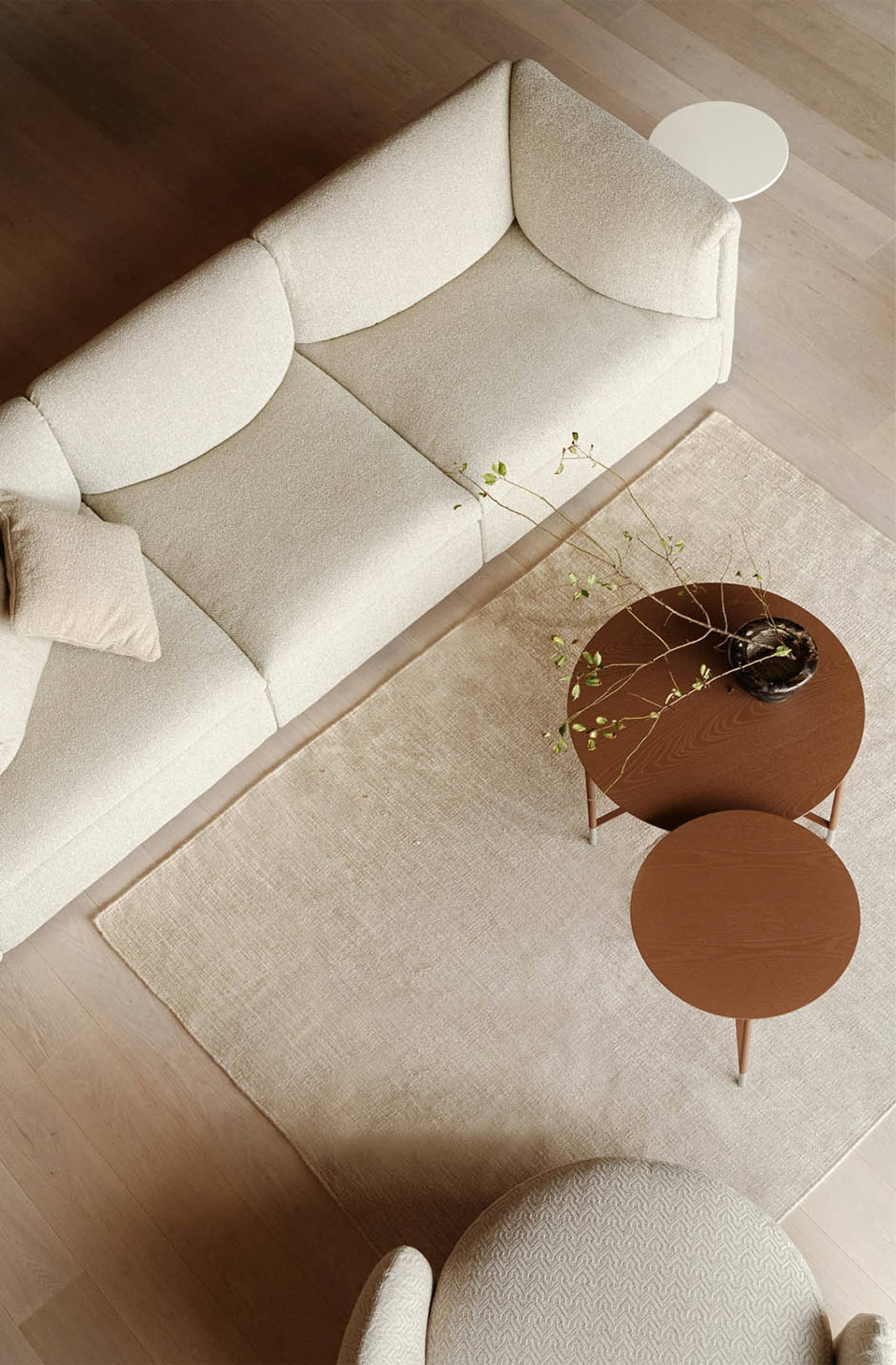 A minimalist living room featuring fabric upholstery, wooden elements, and metal accents.