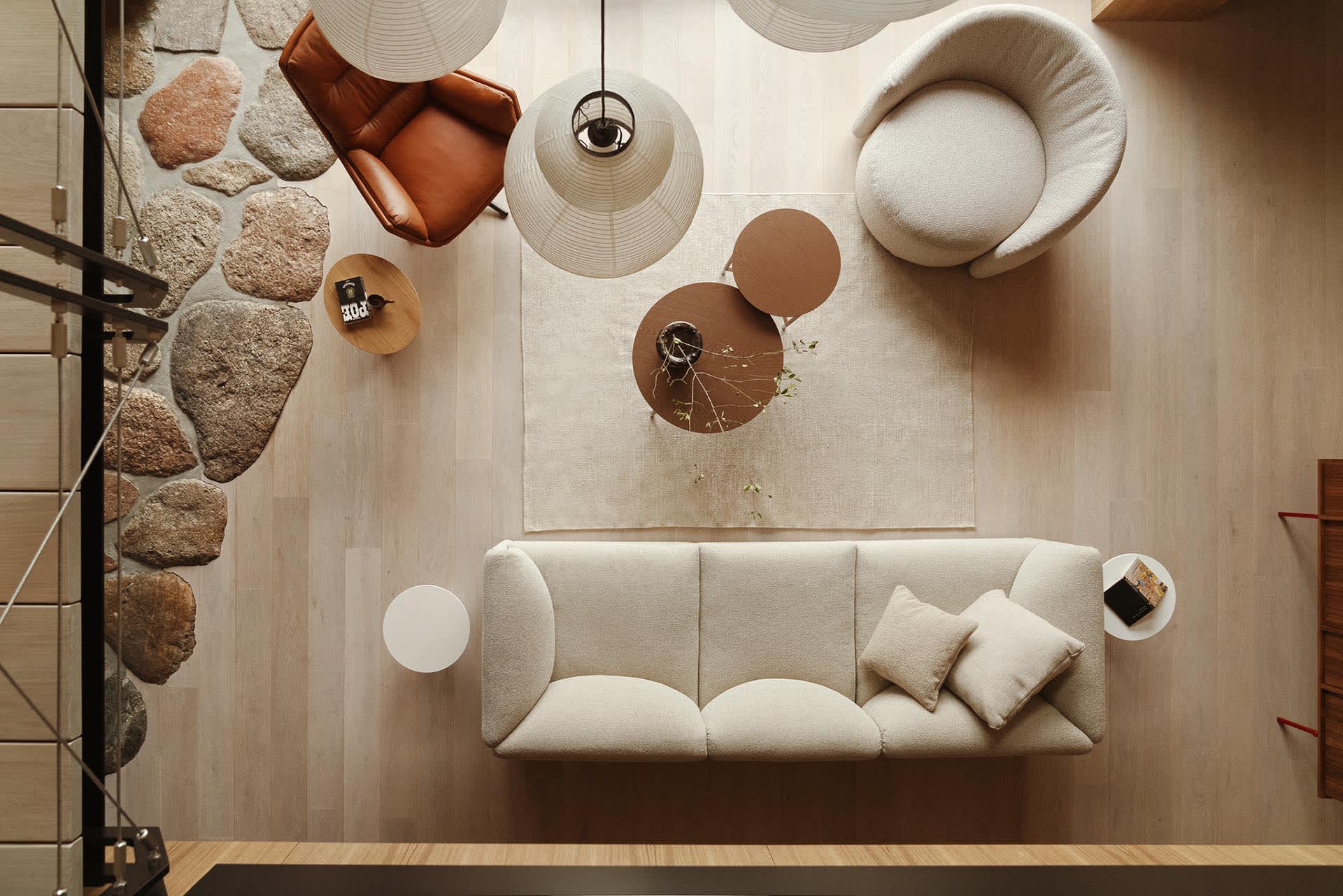 A modern interior living room with parquet flooring featuring a sofa, armchairs, coffee table, and decorative elements such a