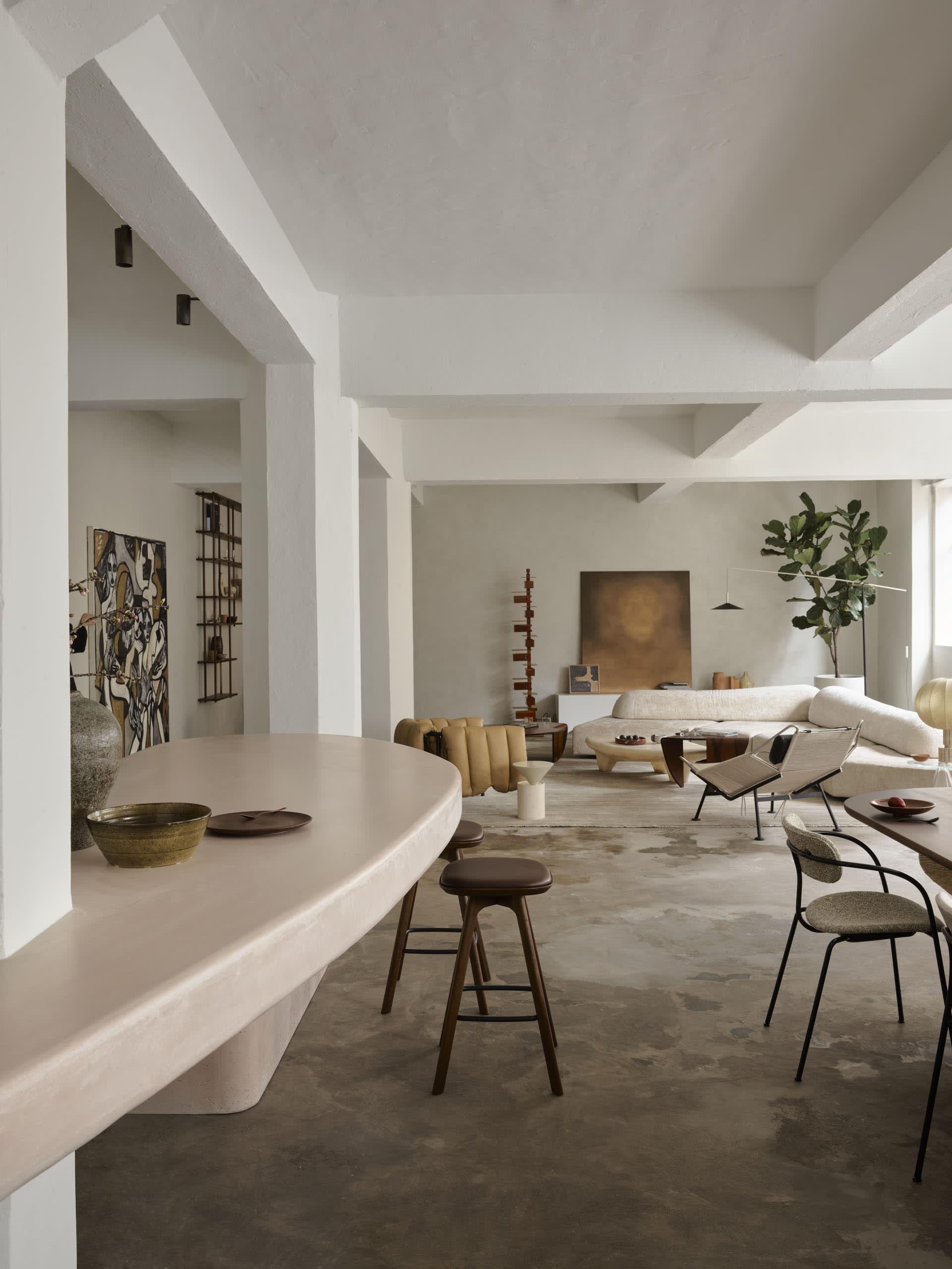 A modern living room featuring a concrete floor, minimalist design, and contemporary furniture.