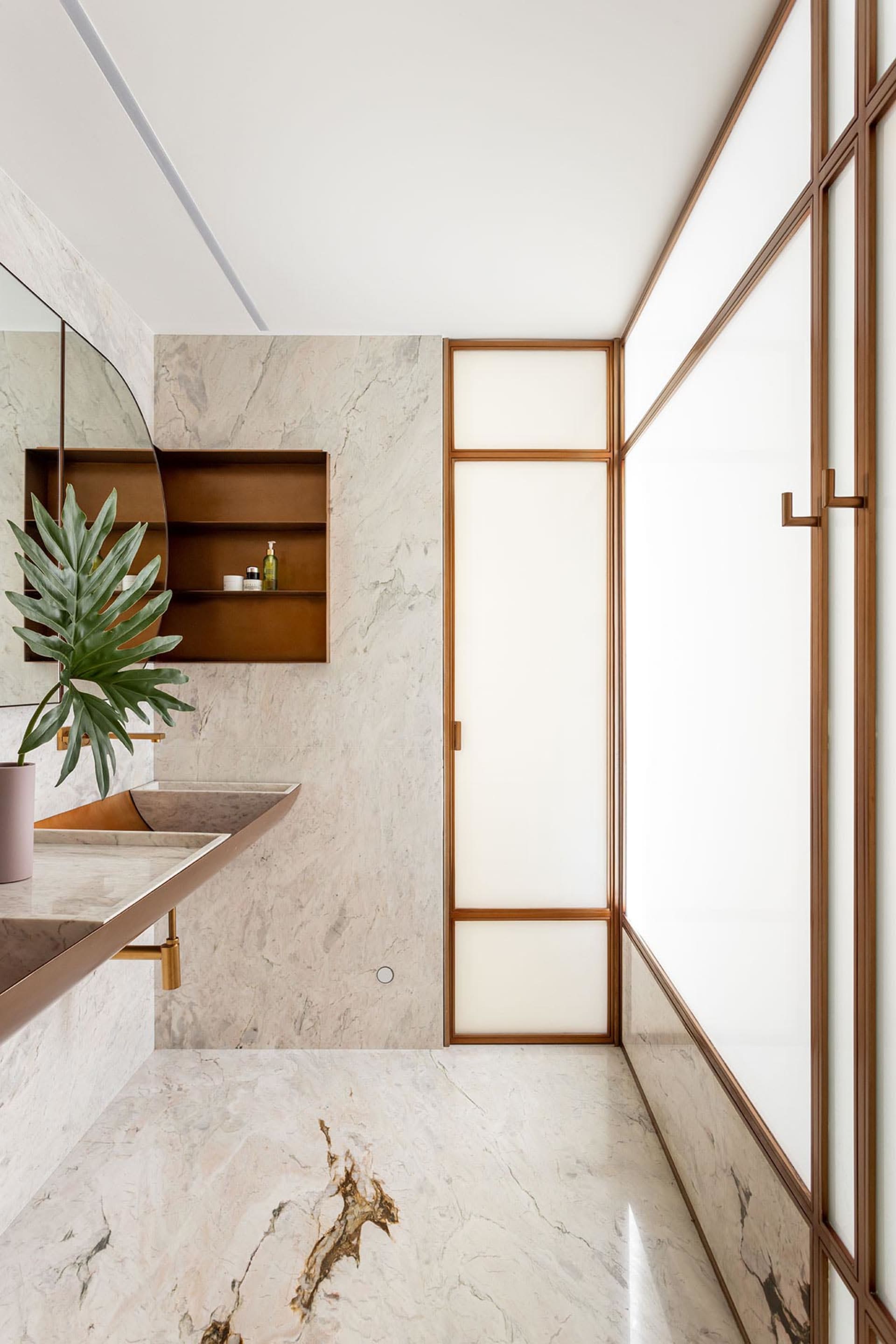 A modern bathroom featuring marble walls and flooring with minimalist design elements.