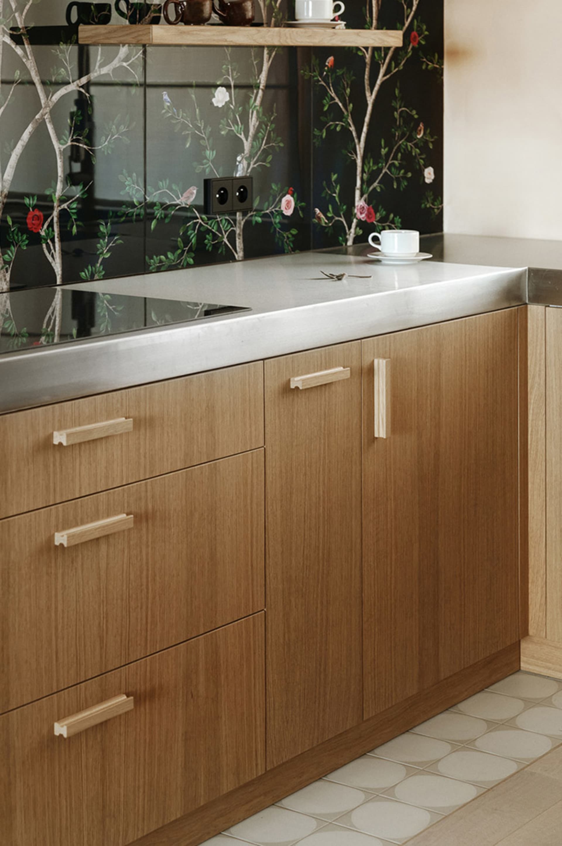 Modern, minimalist kitchen with wooden cabinets and stainless steel countertops.