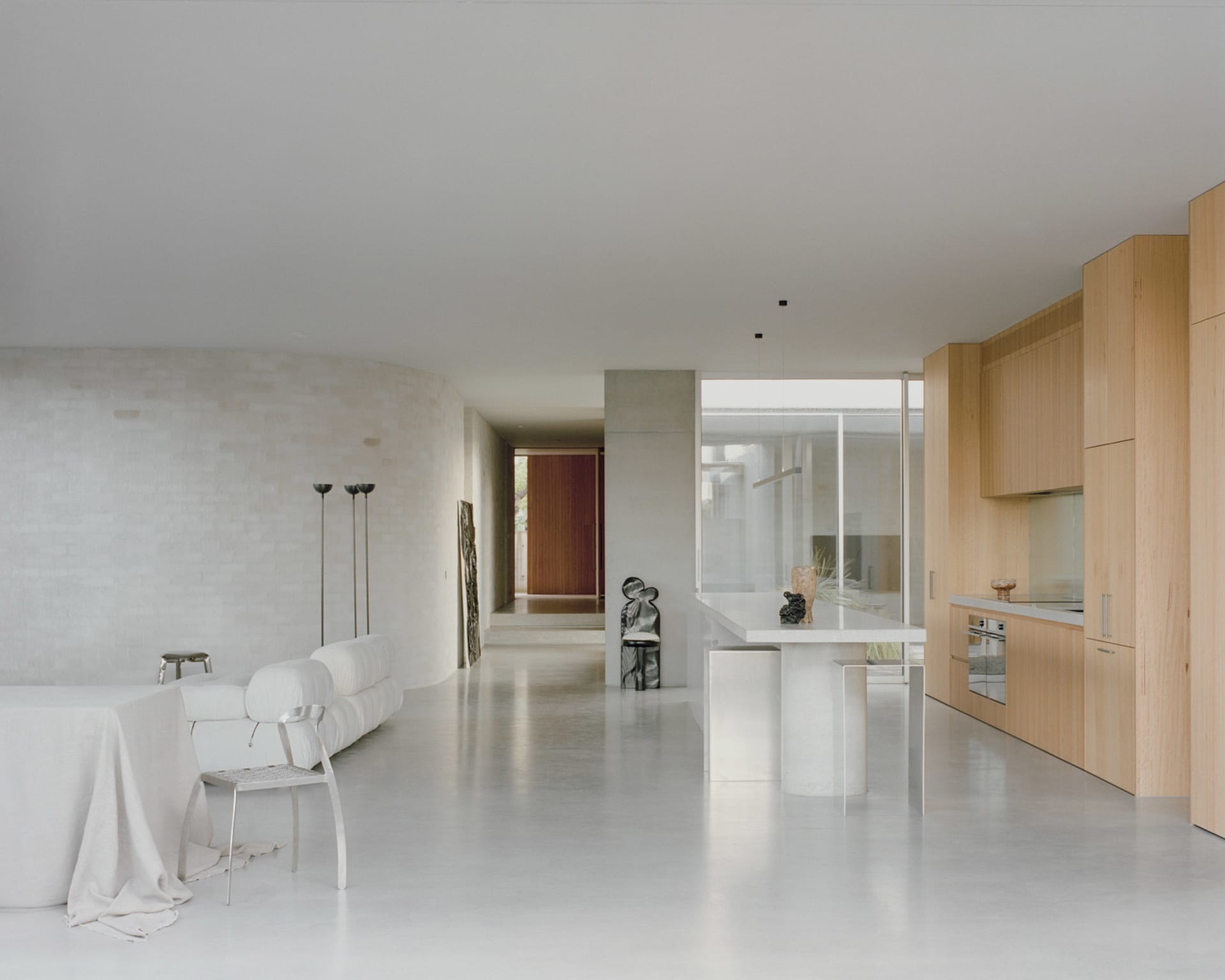 Minimalist residential kitchen with concrete flooring, minimalist furniture, and sleek, modern design.