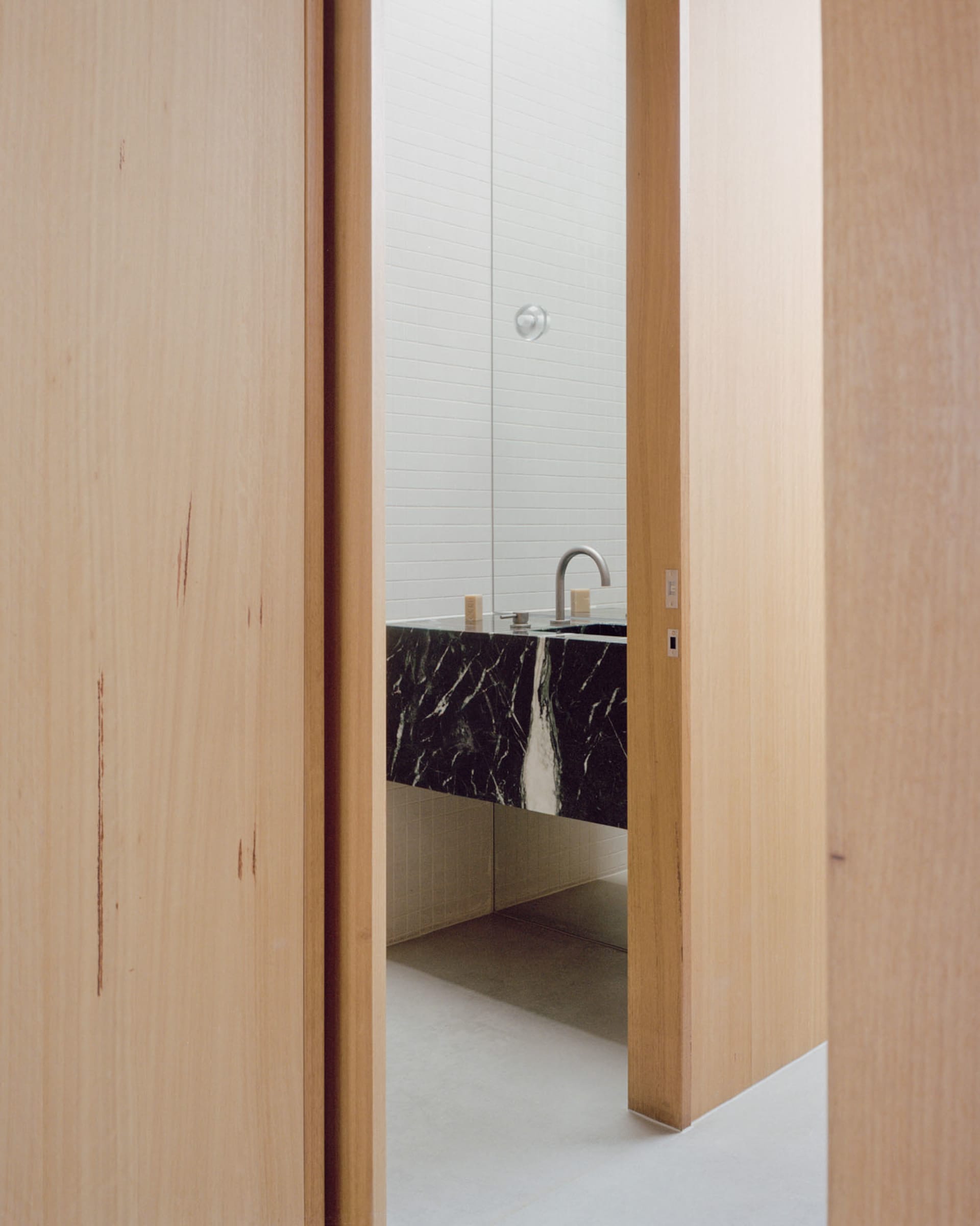 Modern minimalist bathroom featuring marble countertop and flooring.