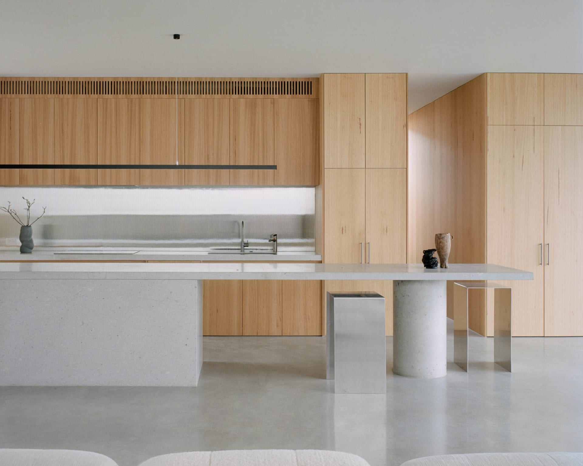 A modern residential kitchen with wooden cabinets and a white countertop.