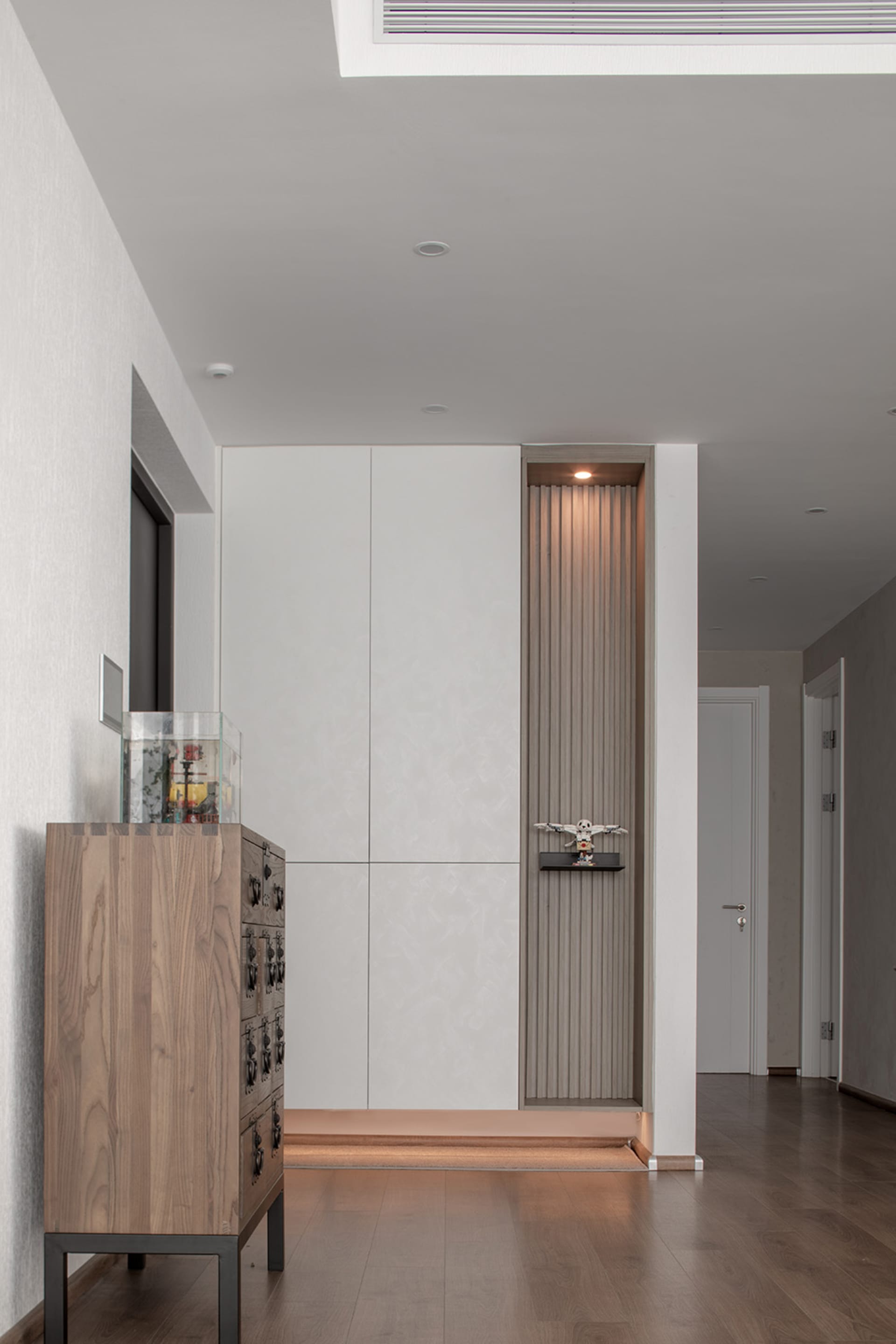 A modern entrance walkway featuring a combination of wooden and ceramic panels.