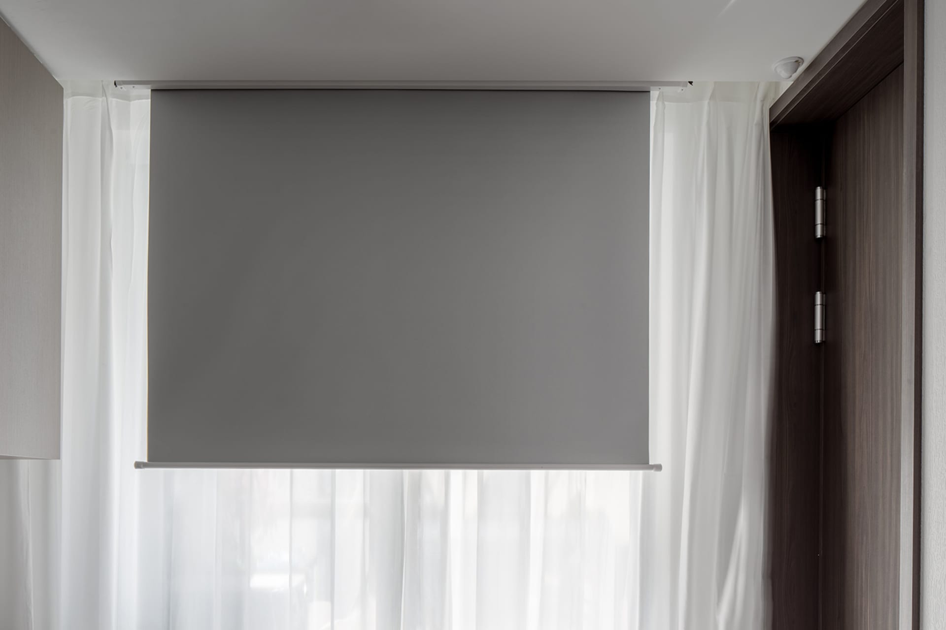 Modern window blinds and sheer white curtains in a contemporary interior design setting