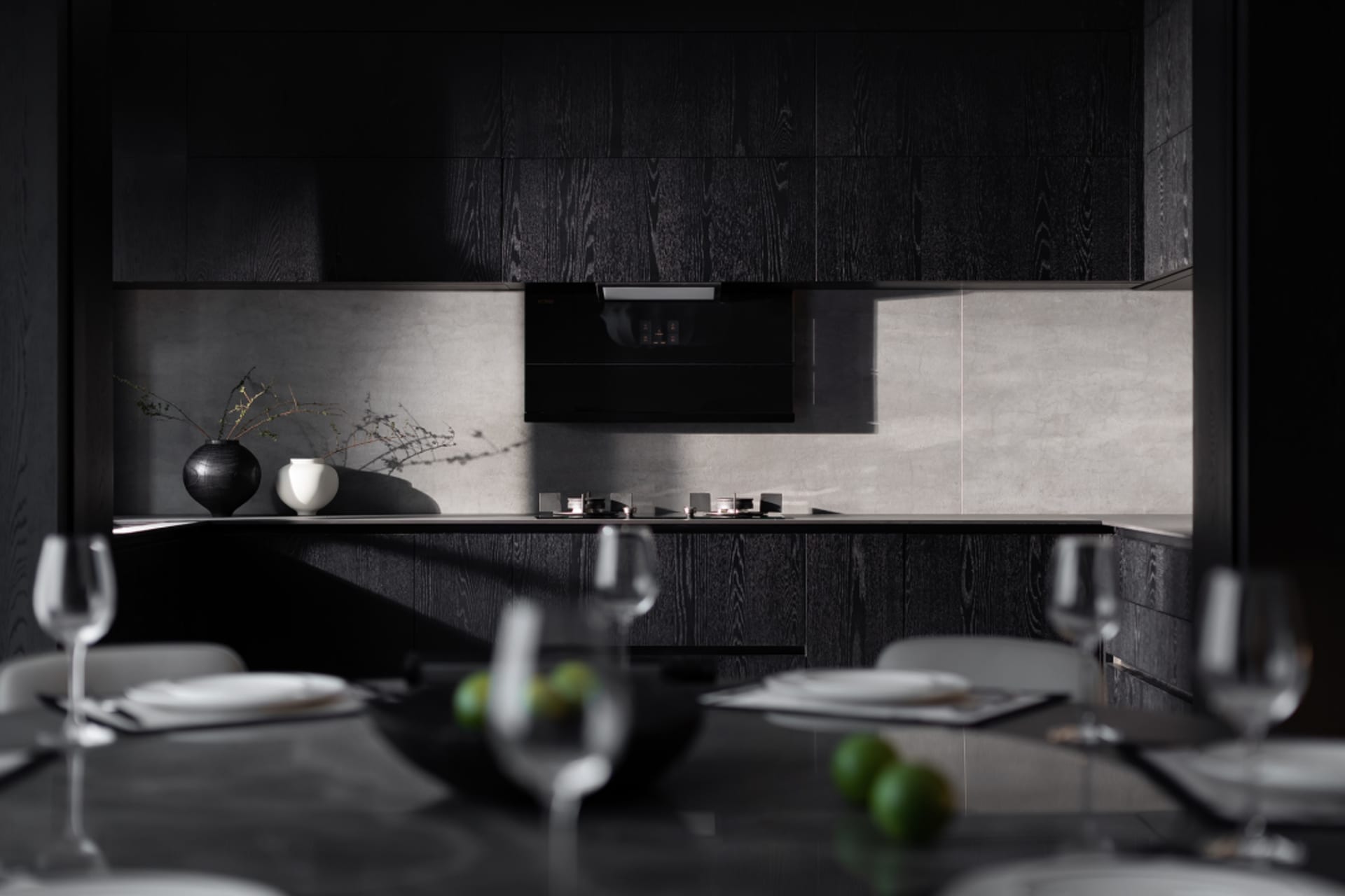 A modern minimalist kitchen with concrete countertops, black cabinets, and white appliances.