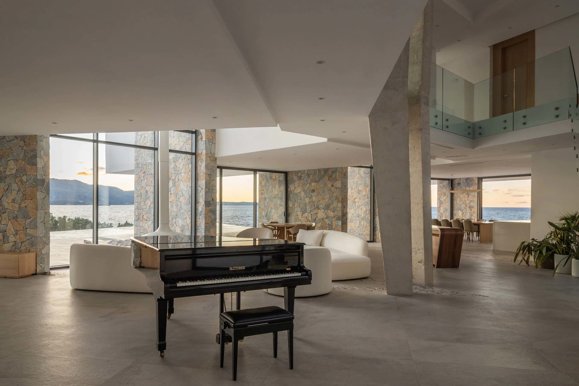A modern residential living room featuring stone, glass, and concrete materials.