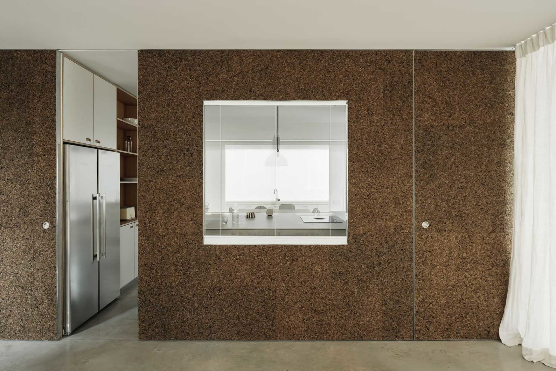 Interior shot of a modern kitchen with cork walls and a glass window