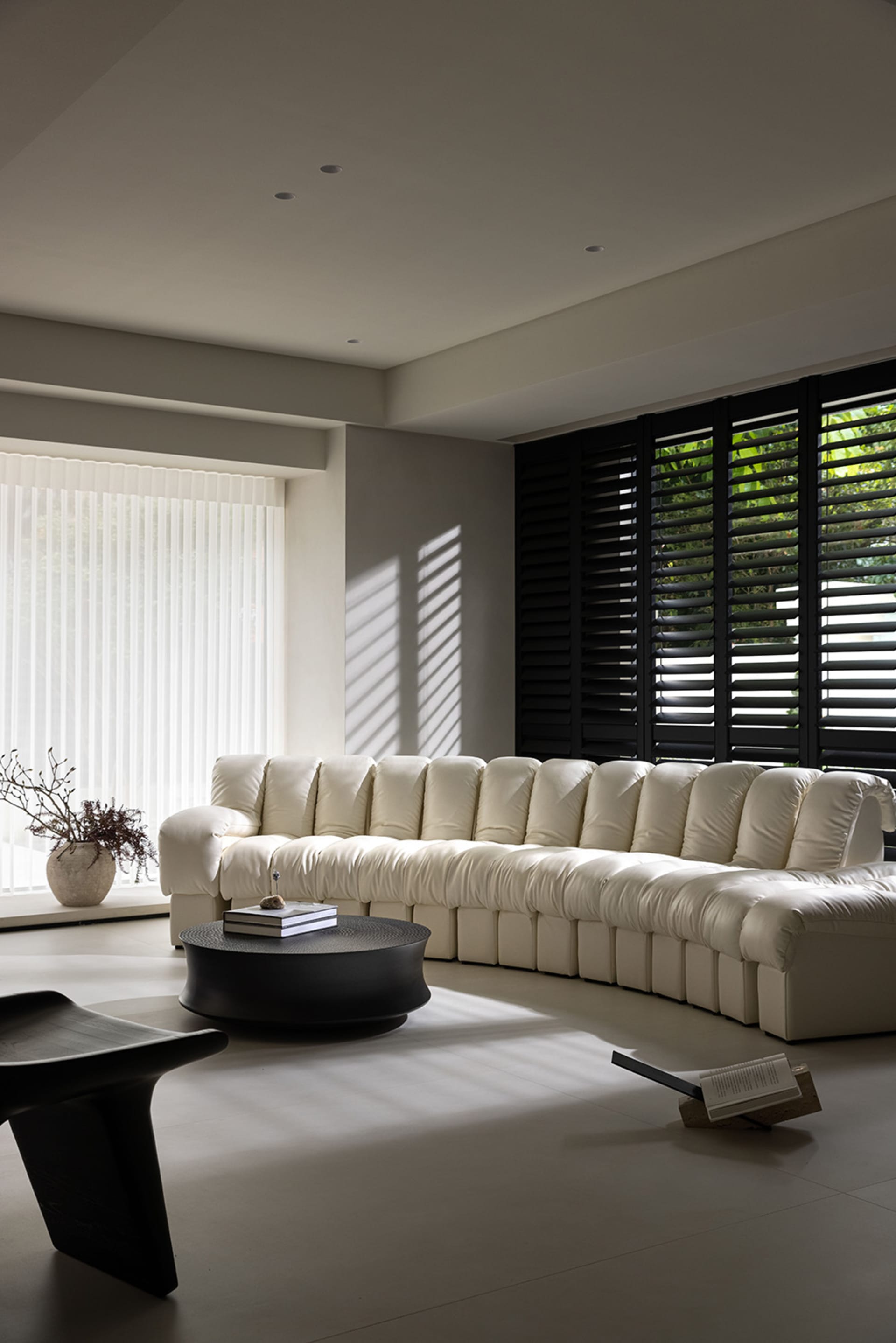 Modern white fabric sofa in a living room with sunlight streaming through the window.