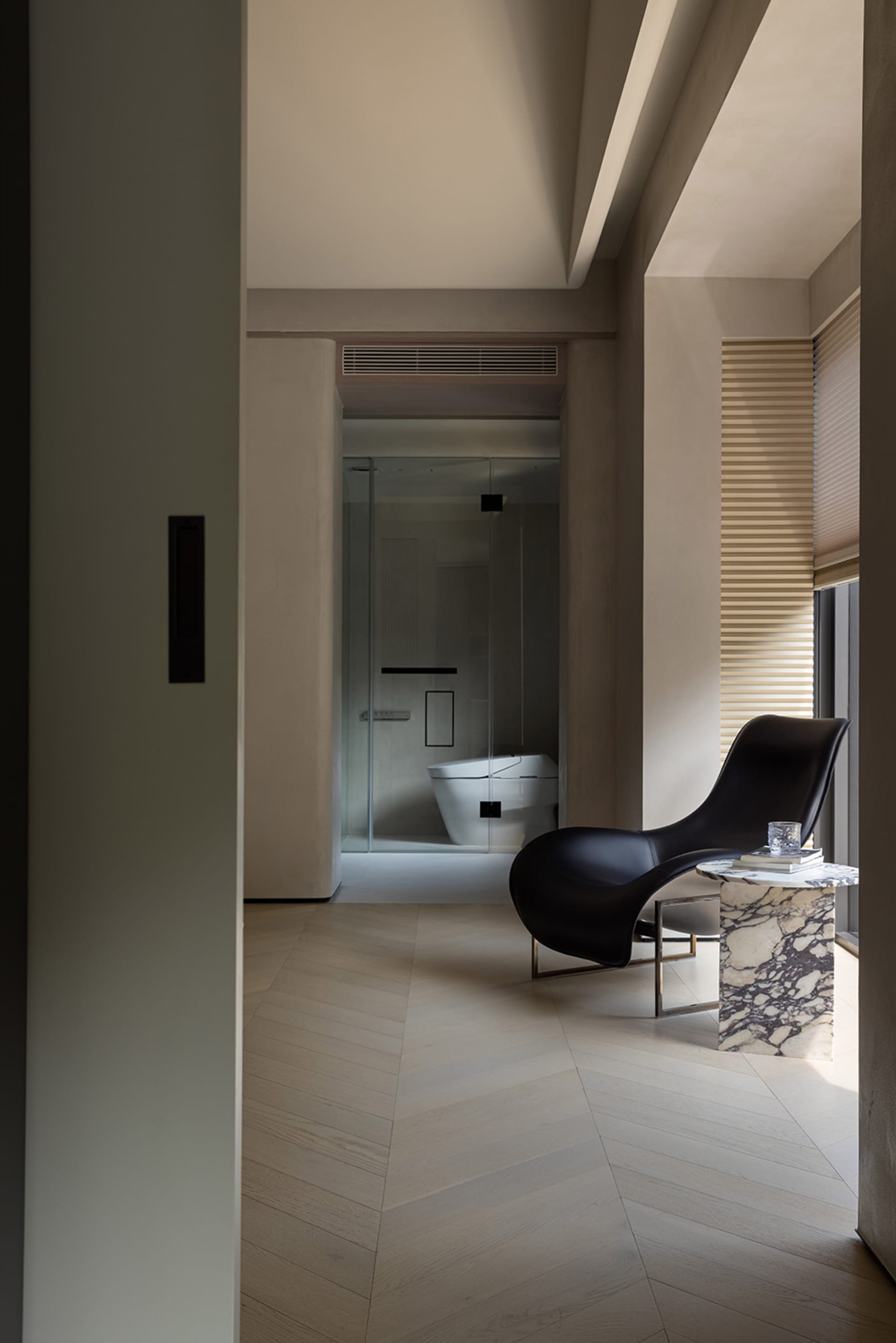 A modern minimalist bathroom featuring glass walls, marble accents, and concrete flooring.