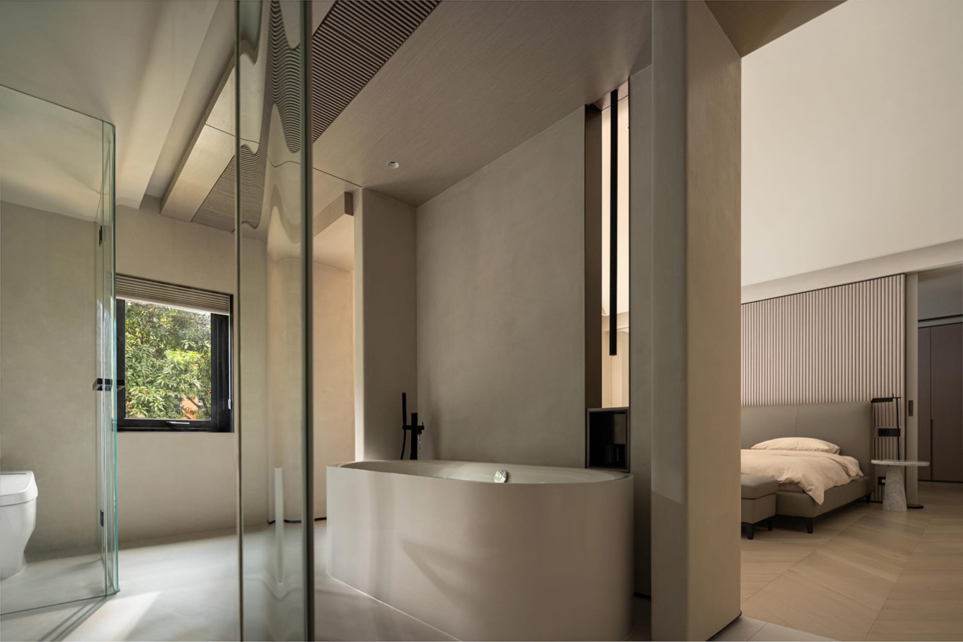 Modern minimalist bathroom featuring a concrete bathtub with a view of lush greenery outside a window.