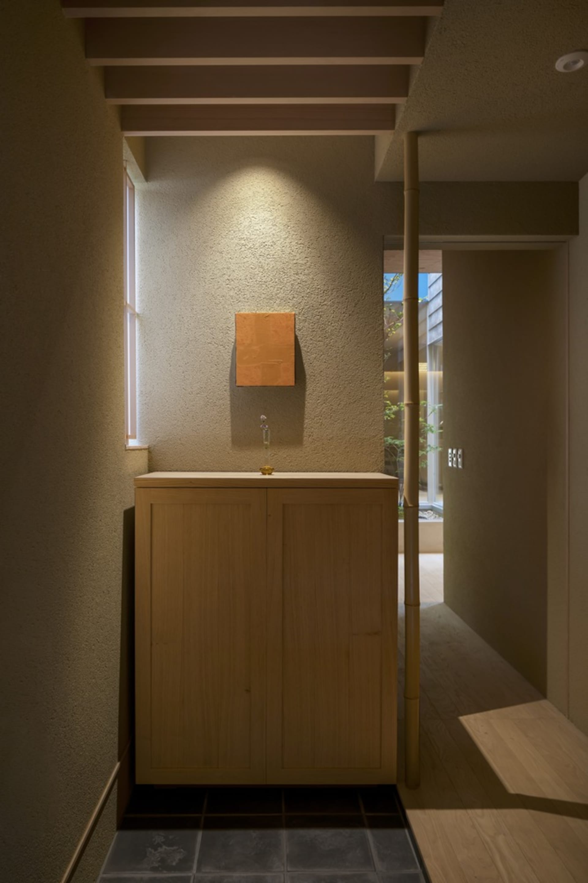 Modern industrial entryway with wooden cabinet and minimalist design.
