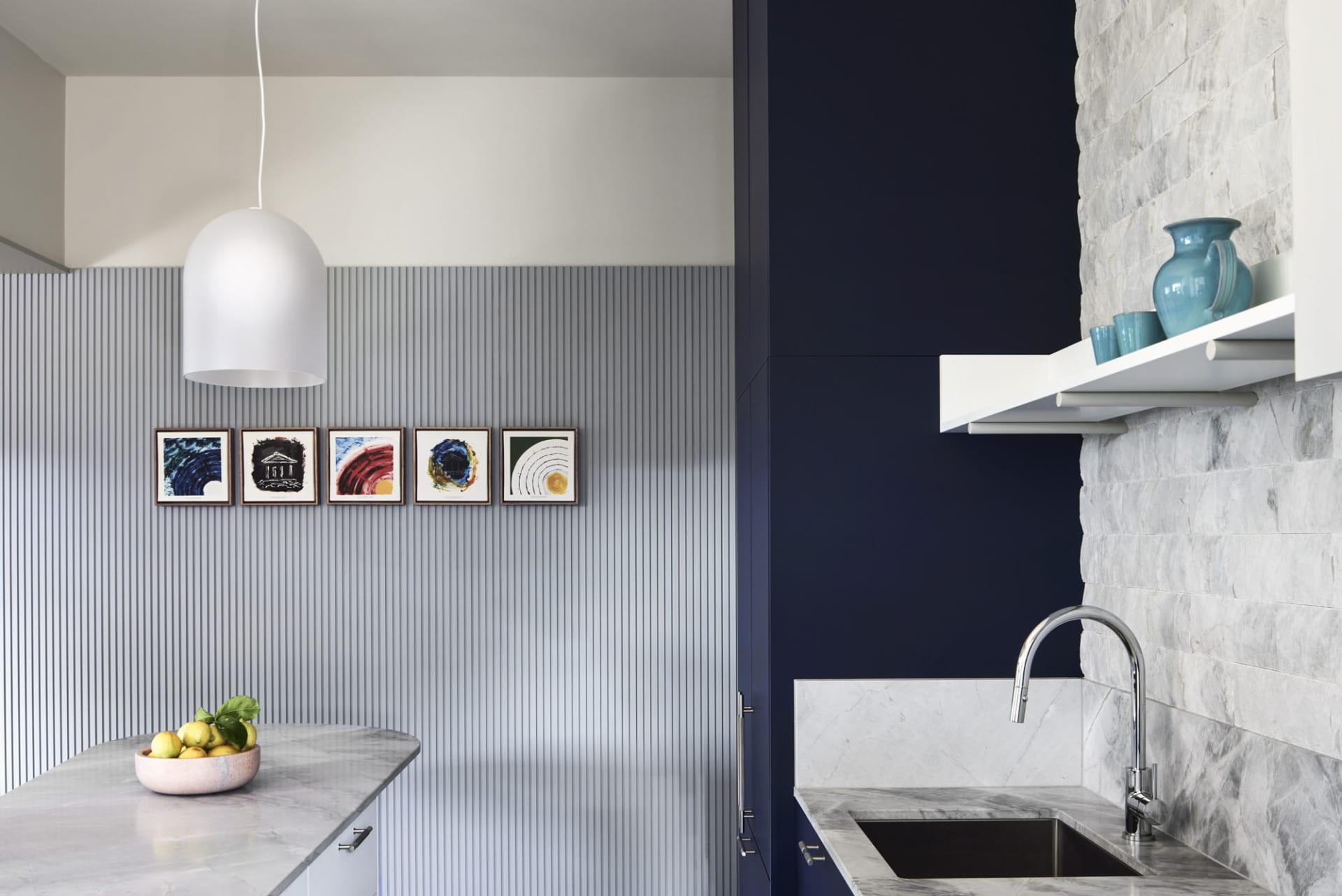 Modern kitchen with marble countertops and minimalist design elements.