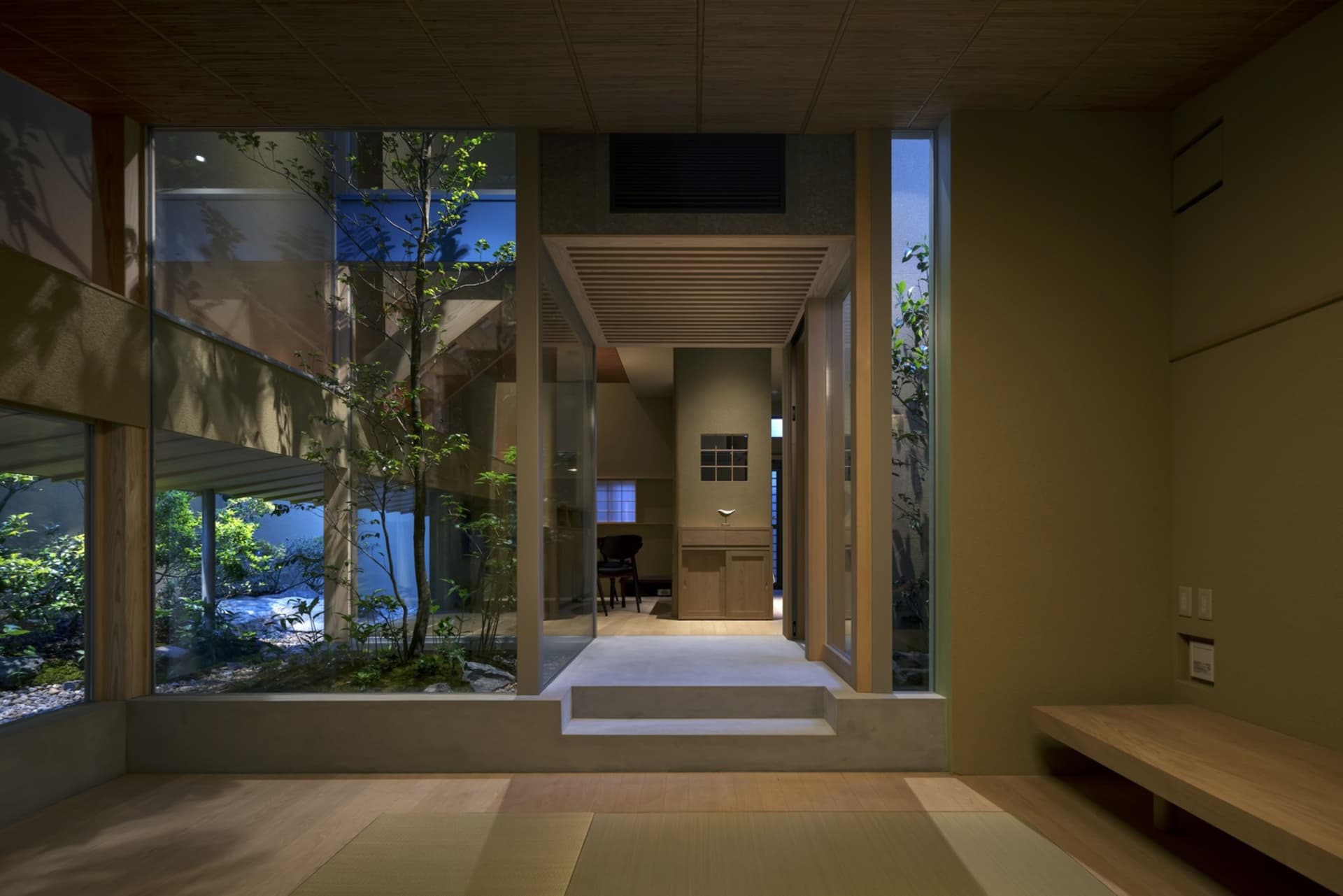 A modern Japanese-style residence featuring glass walls and wooden elements.