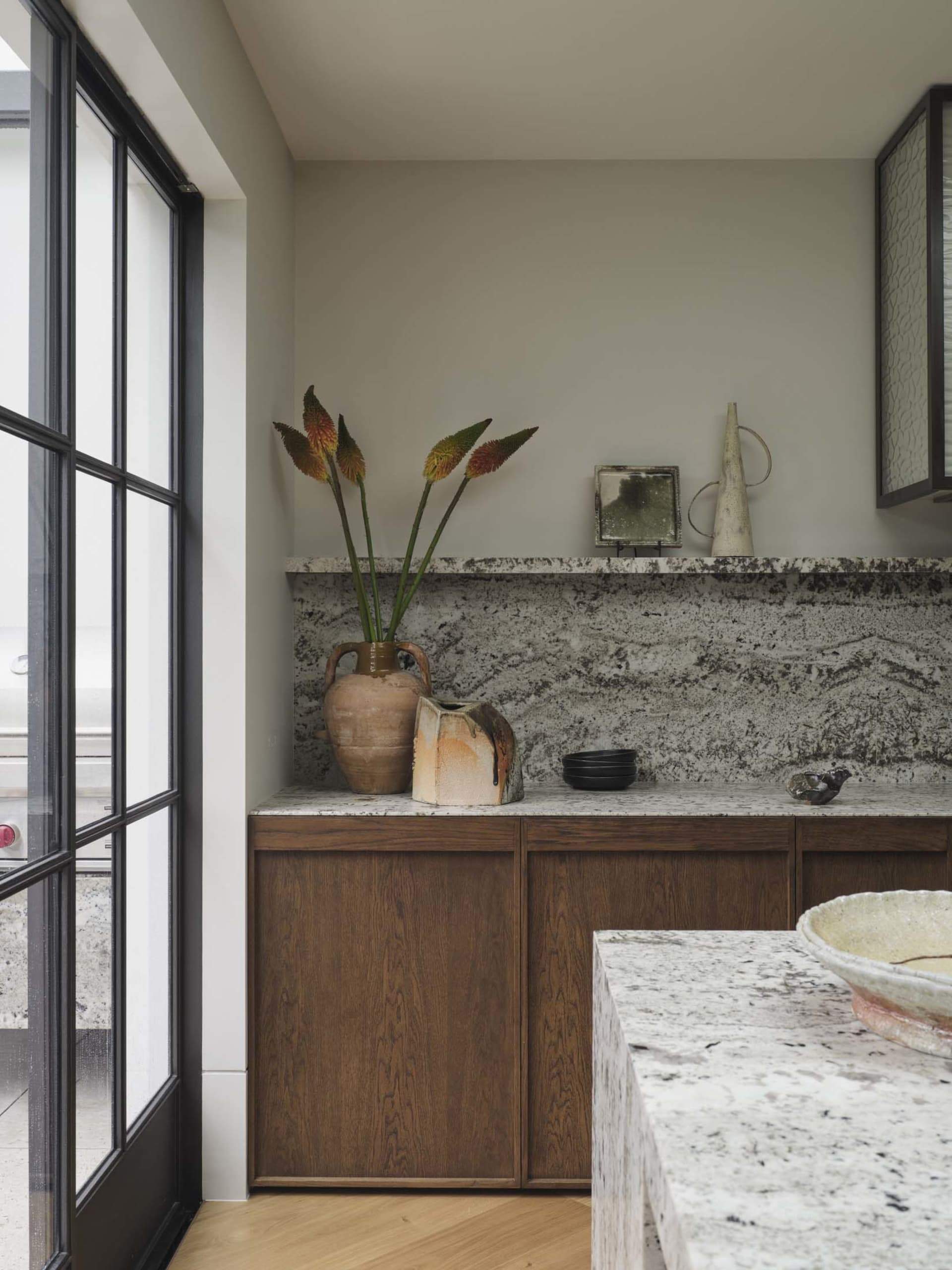 Modern kitchen with granite countertops, wooden cabinets, and decorative ceramics.