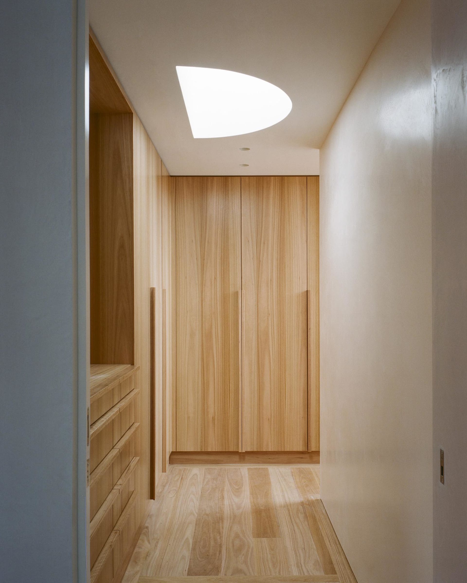 Modern closet with wooden shelves and ceiling light cutout