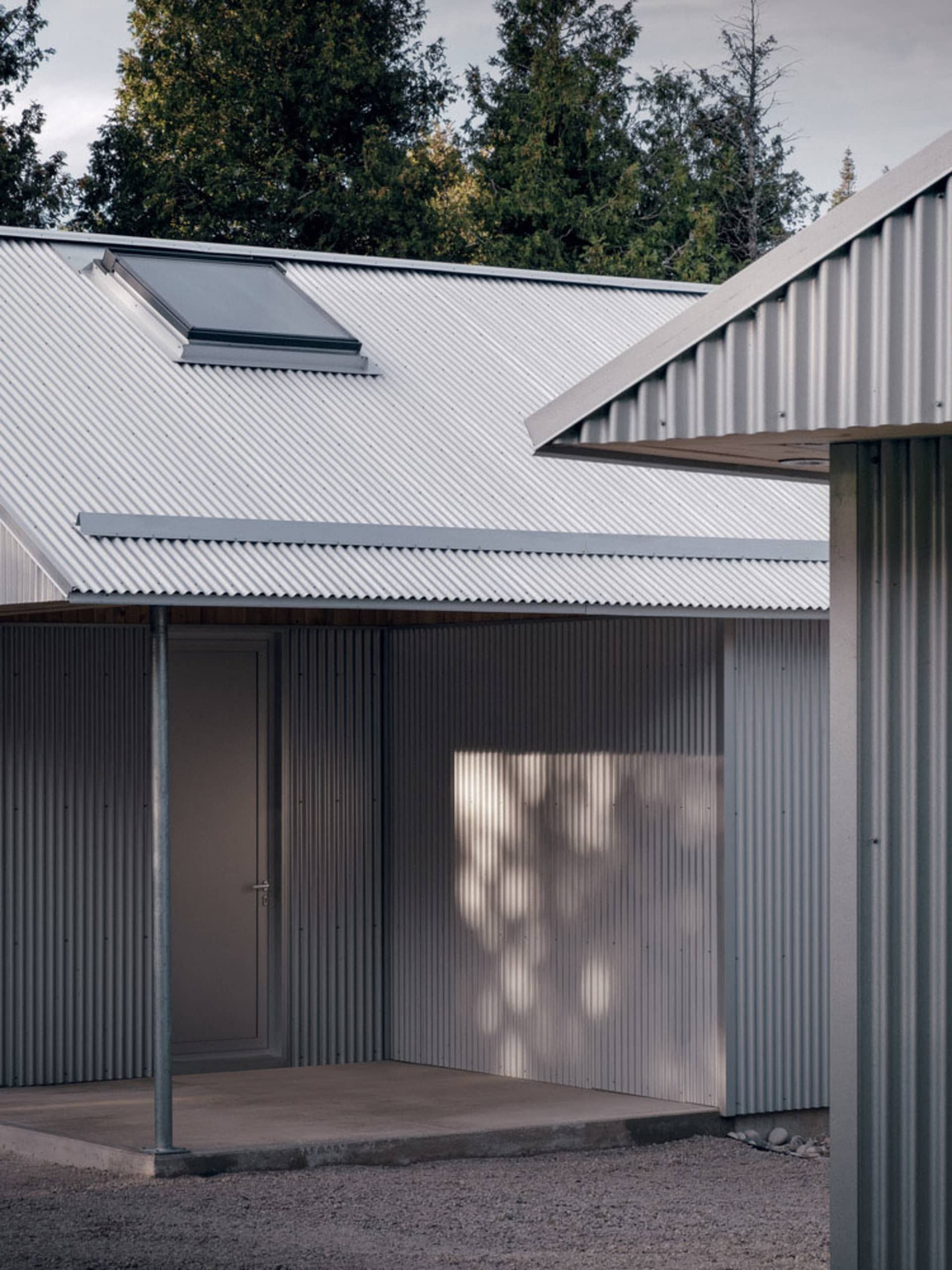 Modern residential entryway featuring metal-clad exterior and skylight.