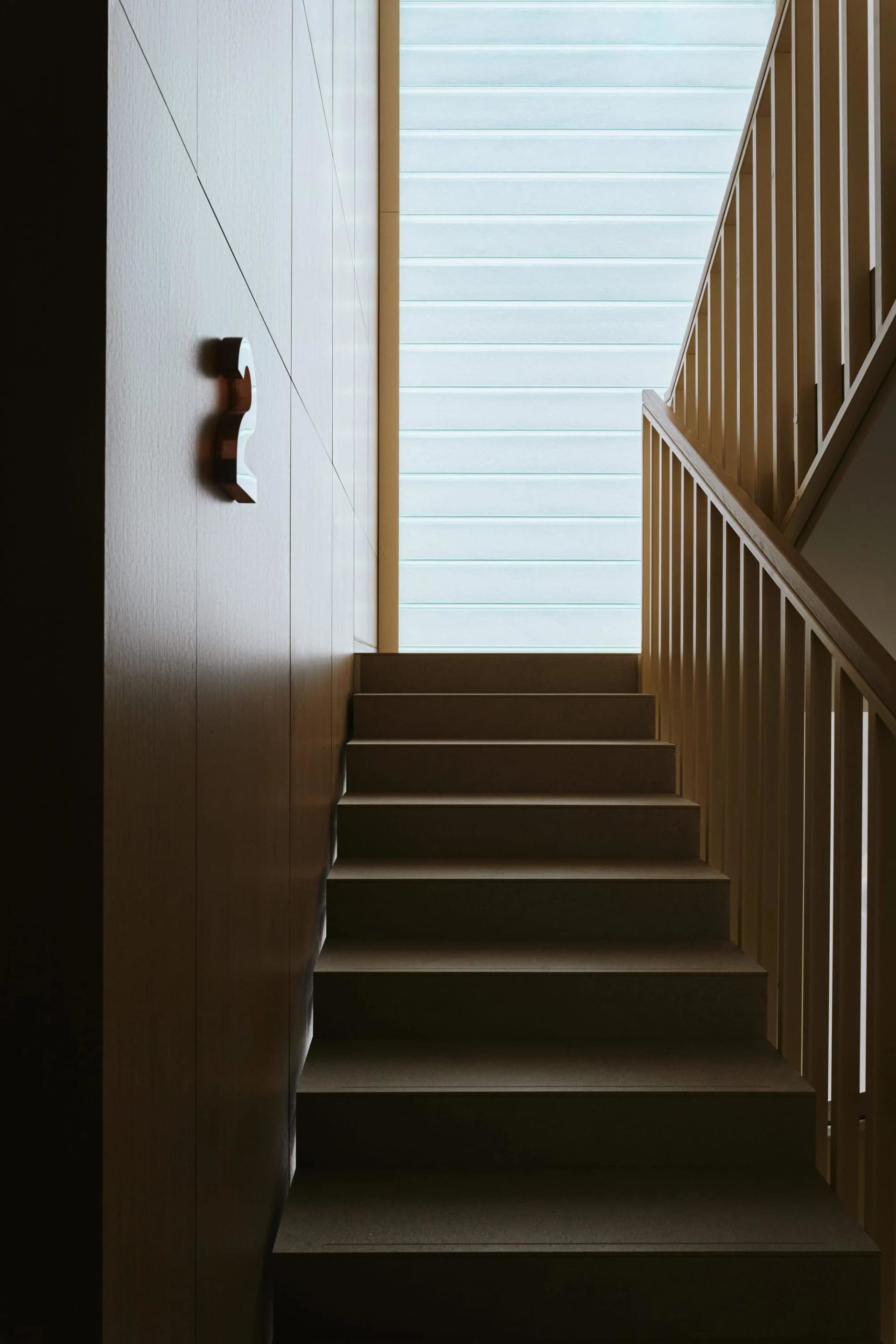 A modern interior space featuring hardwood flooring and concrete stairs.