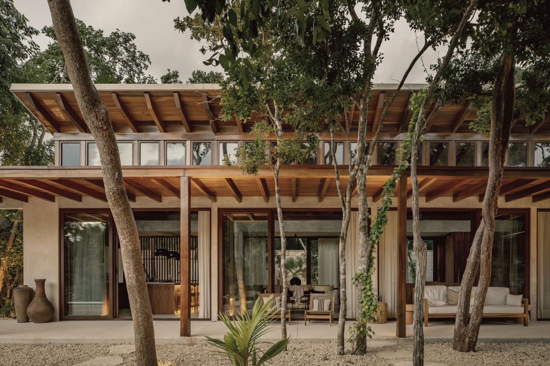 Modern residential exterior with wooden accents, concrete walls, and glass doors.