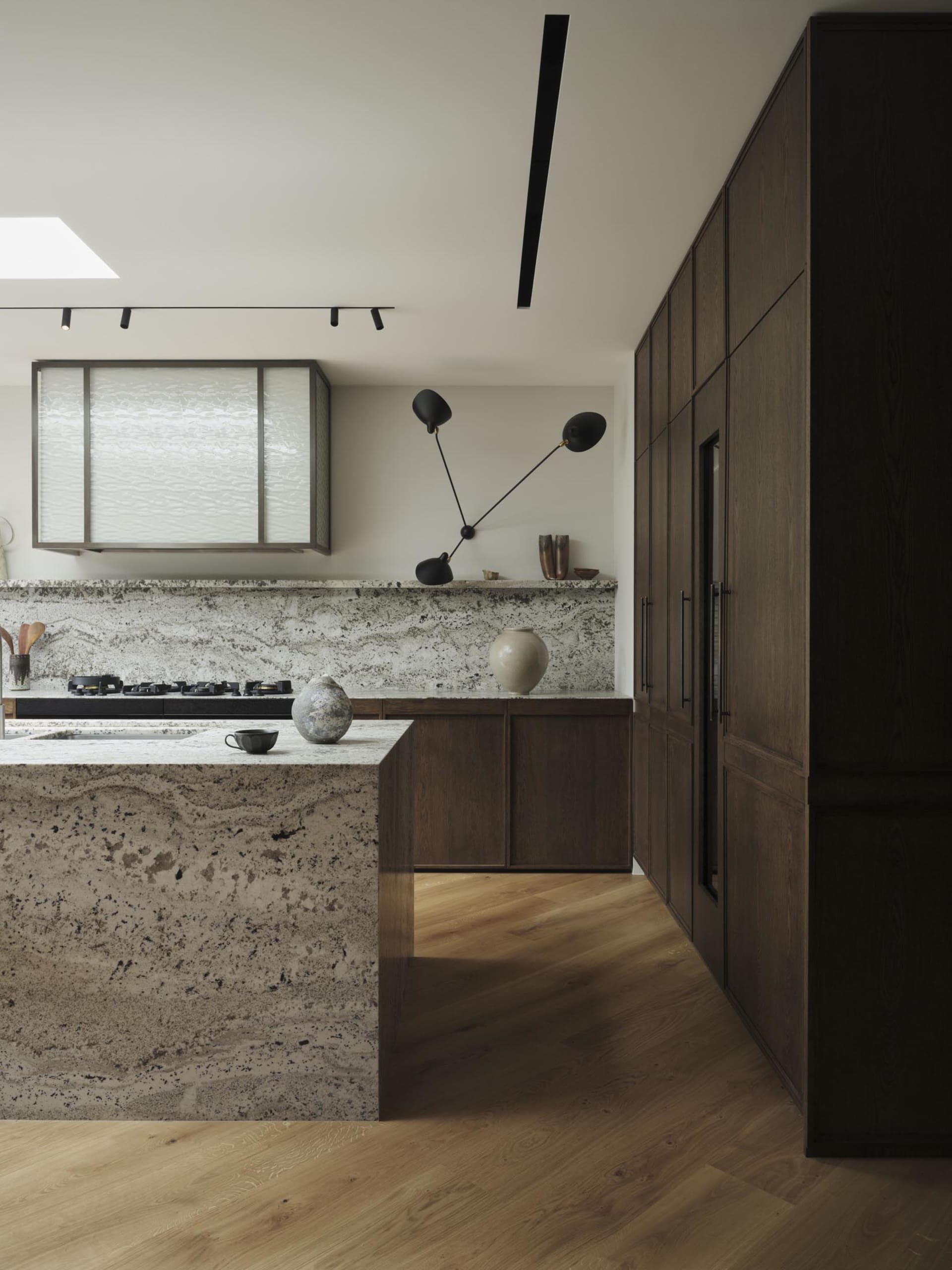 A modern kitchen featuring granite countertops and minimalist design elements.