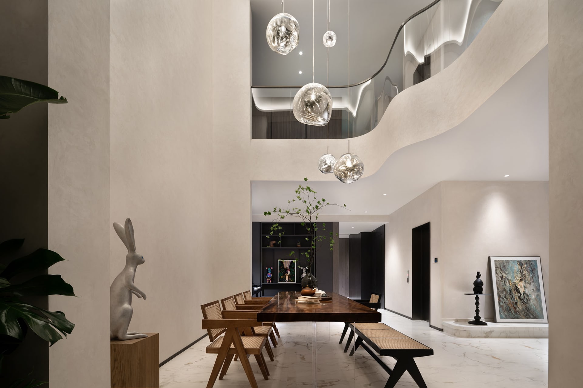 A modern minimalist dining room featuring a wooden table and chairs, with a contemporary light fixture and minimalist decor.