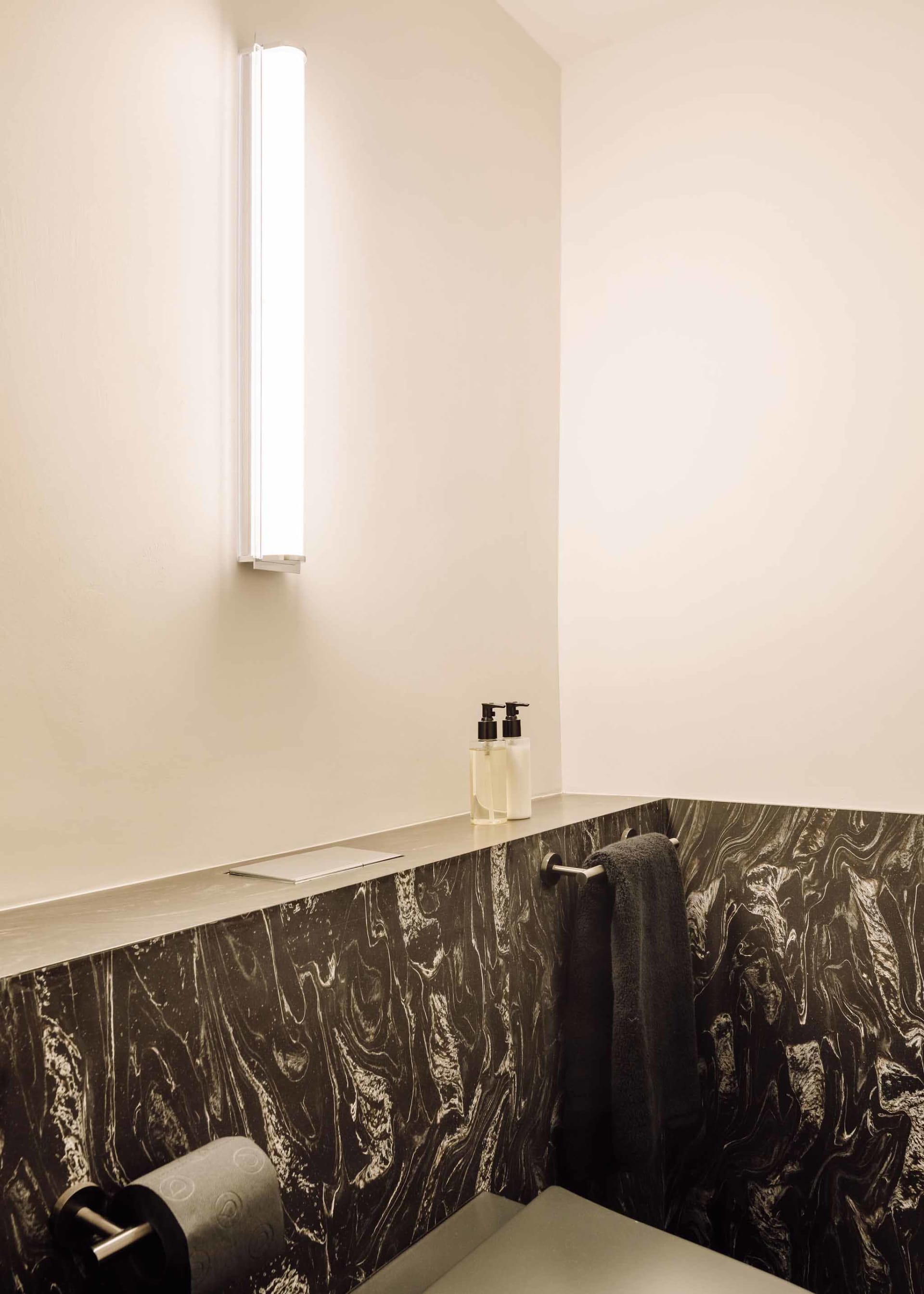 Modern minimalist bathroom featuring a slide with marble and concrete materials.