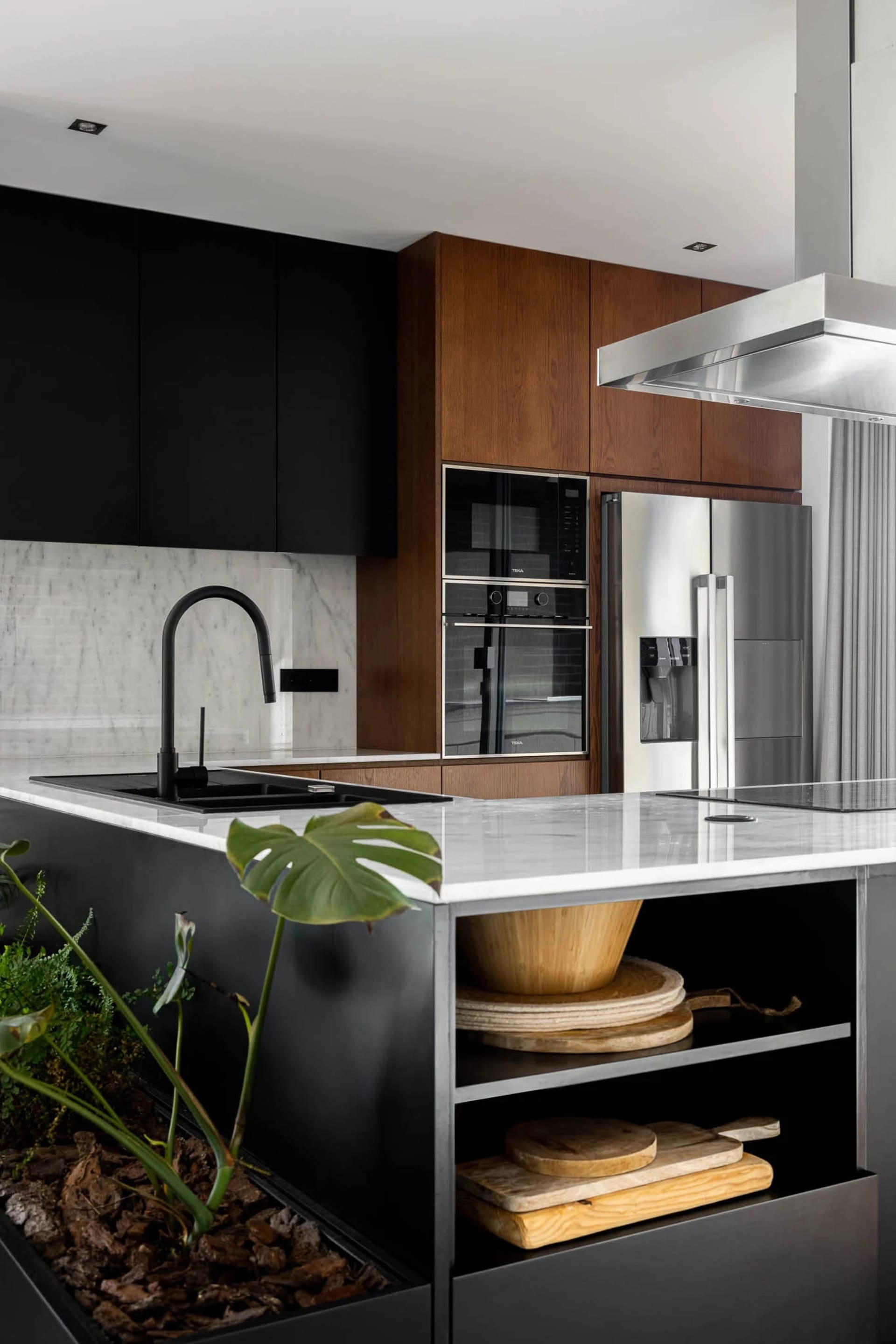 Modern kitchen interior featuring marble countertops and stainless steel appliances.