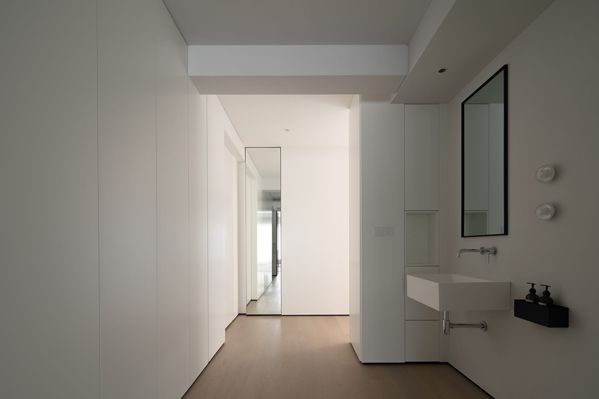 A minimalist bathroom with white materials and a modern, clean design.