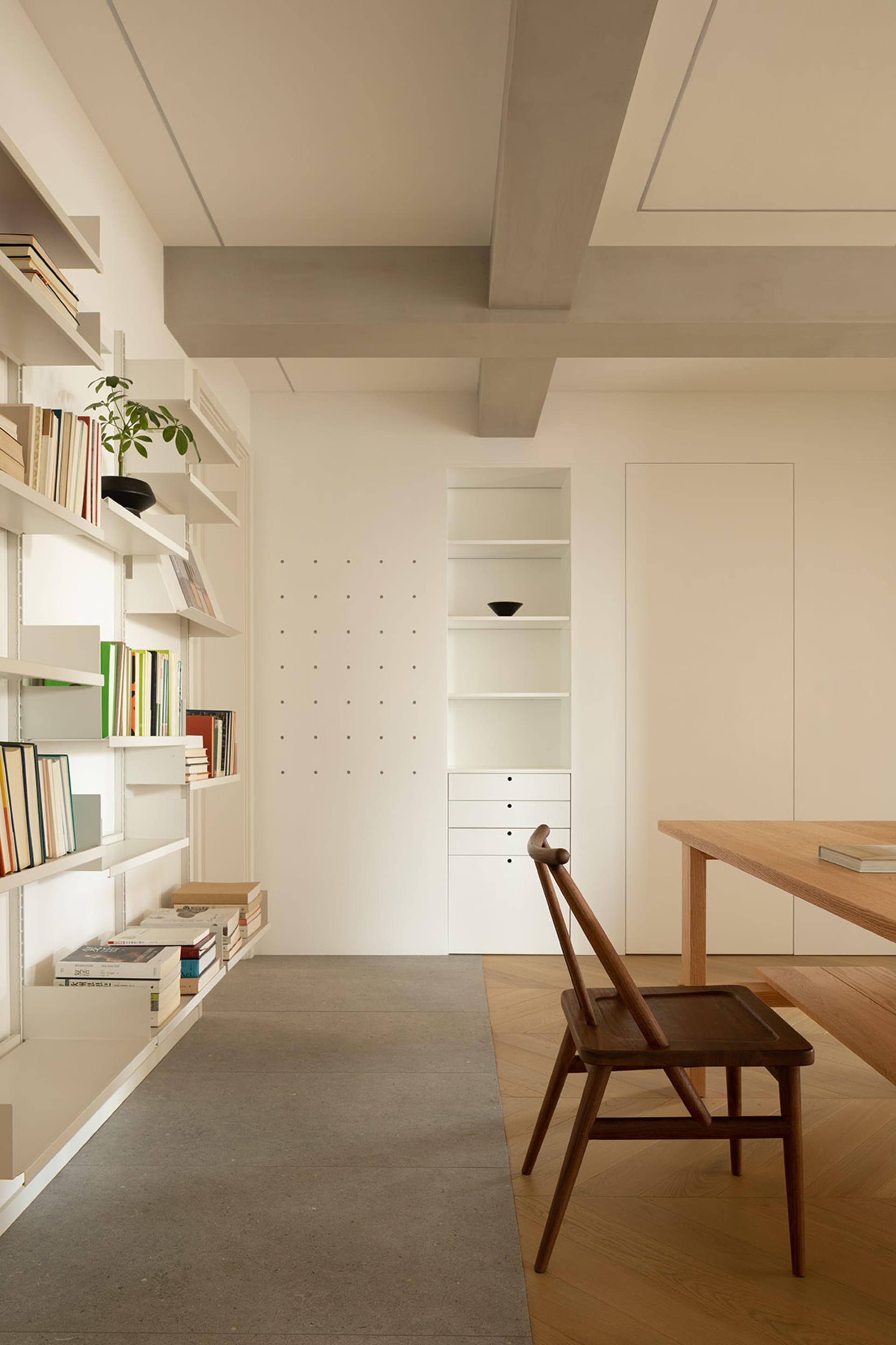 Minimalist home office with white walls and wooden furniture.
