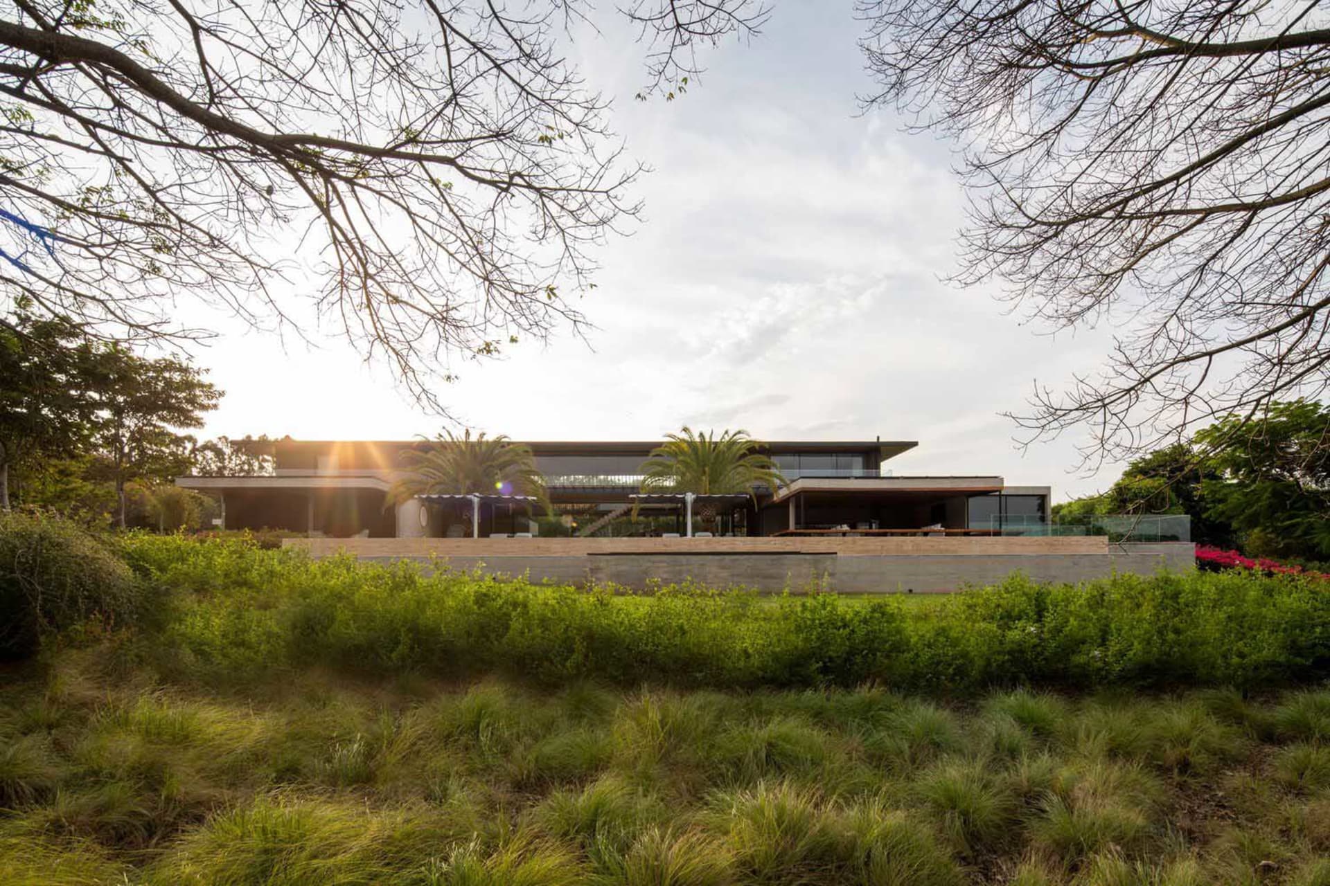 A modern residential exterior with glass, timber, and concrete elements