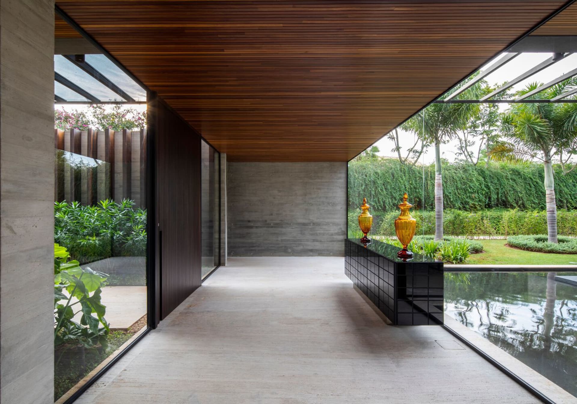 Modern entrance featuring concrete floor and wooden ceiling with large glass windows.