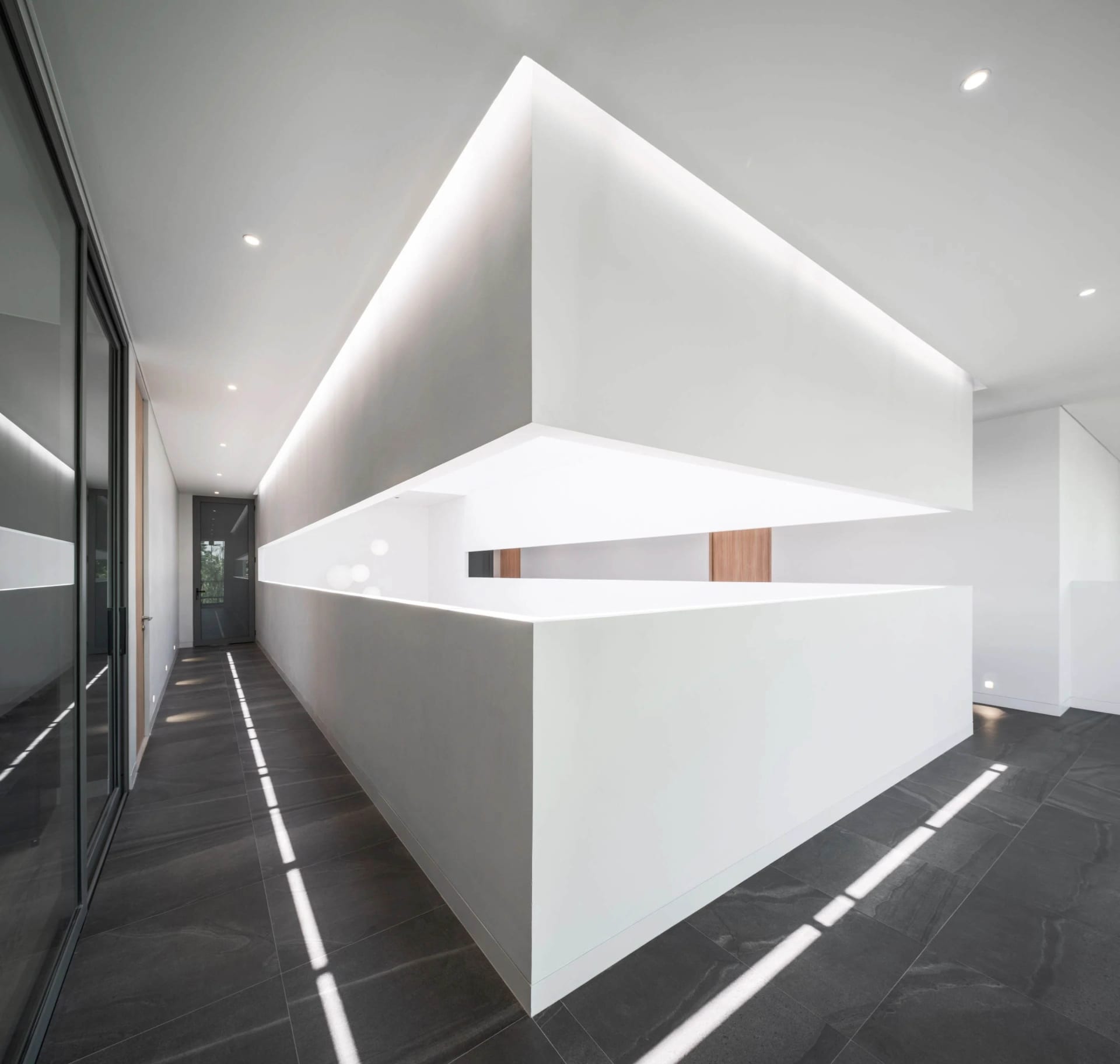 A minimalist office interior featuring concrete walls and flooring.