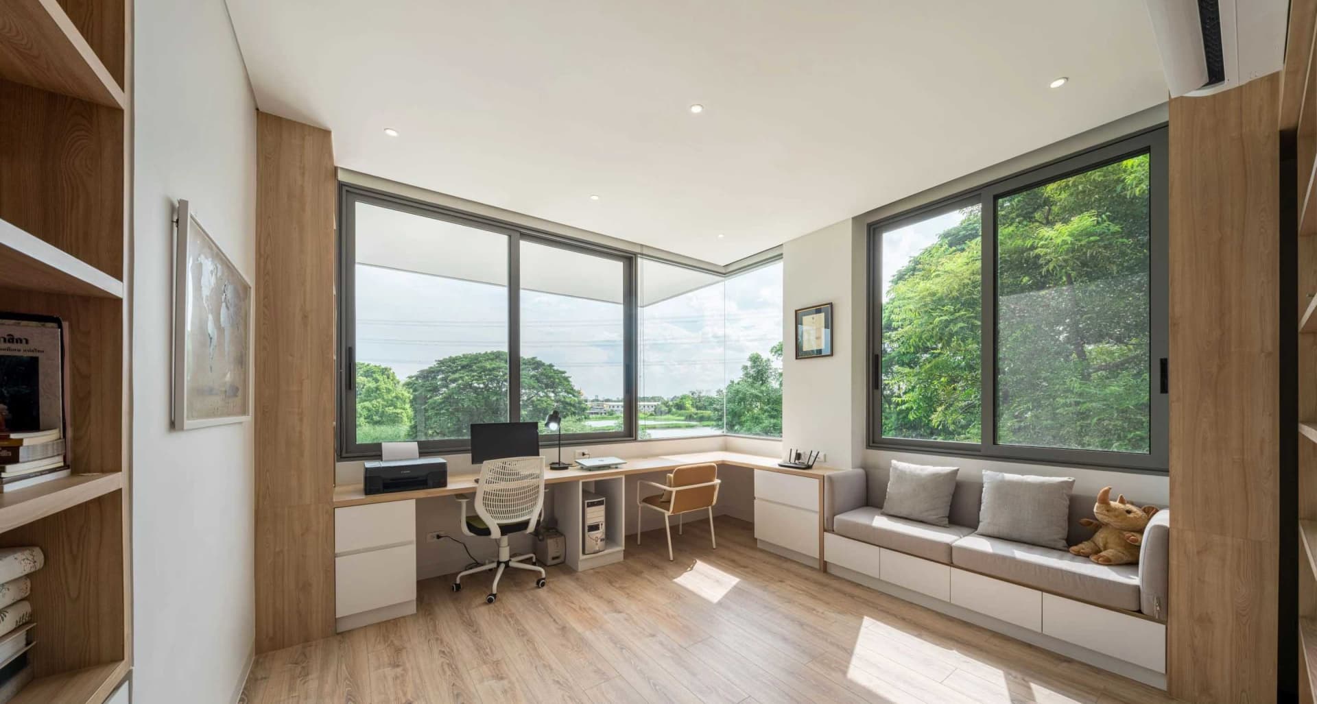 Modern home office with a desk, chairs, and a built-in couch.