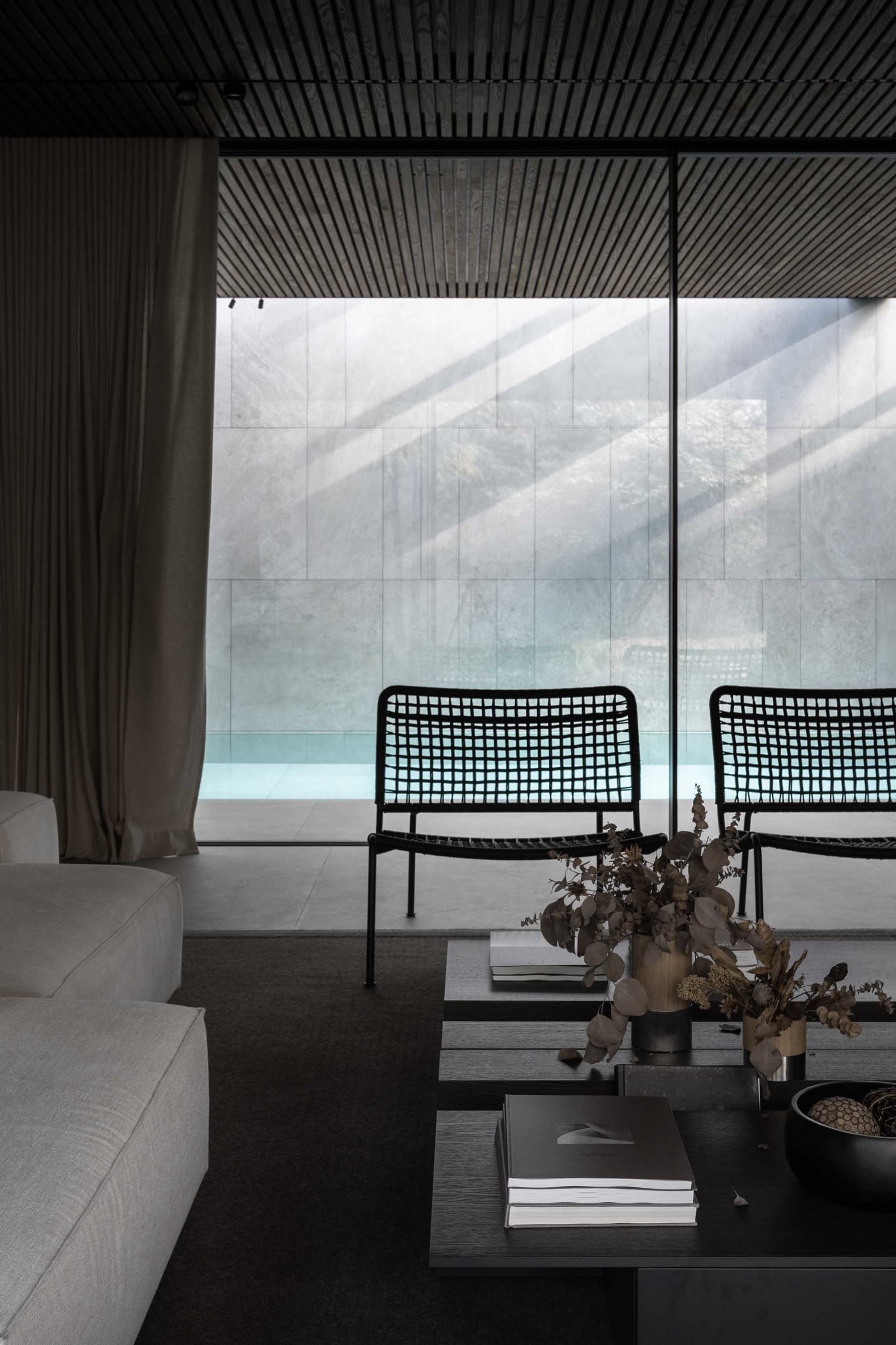 Modern living room with minimalist design featuring concrete furniture and walls.