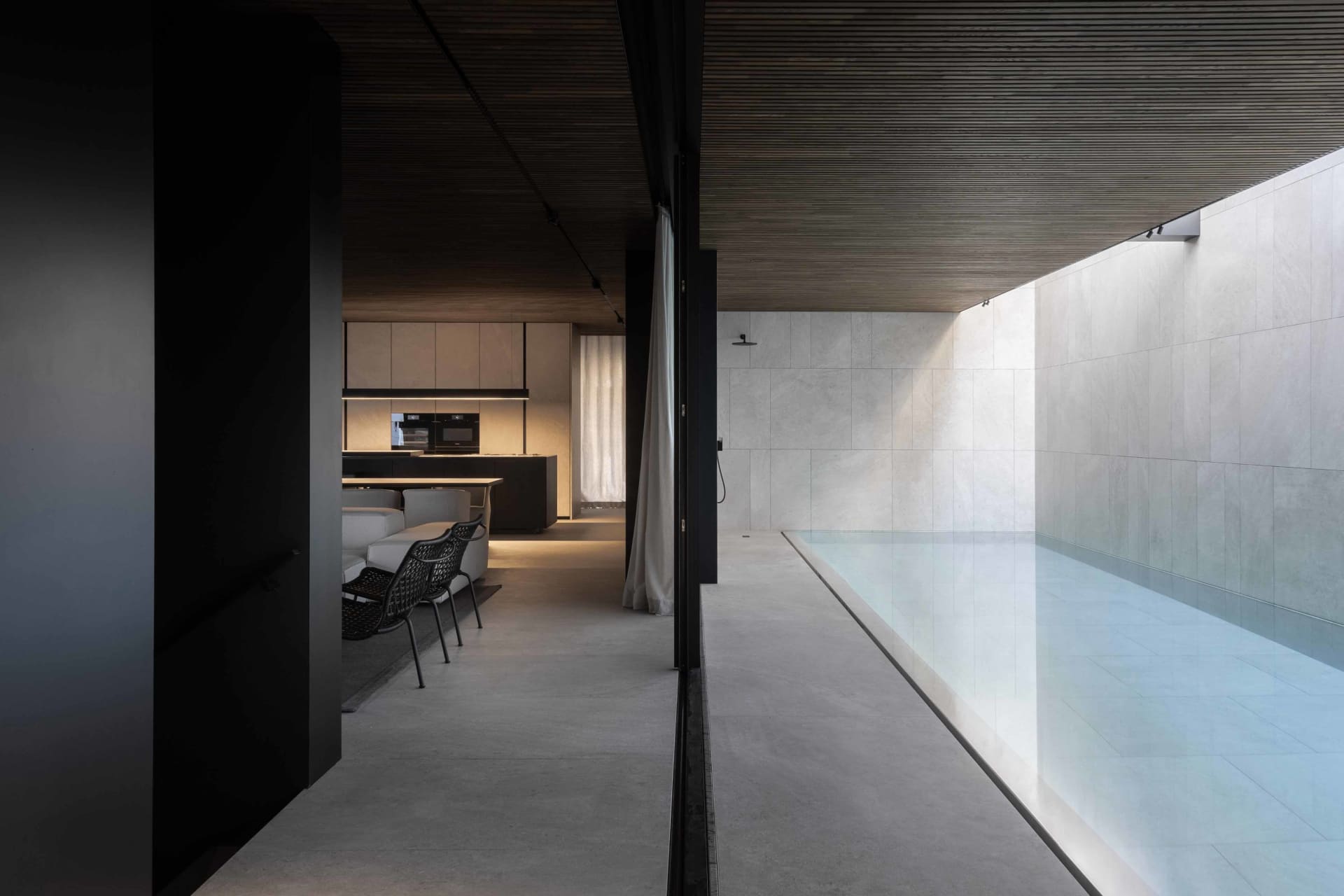 Modern, industrial-style interior design featuring minimalist concrete walls and transparent glass elements.