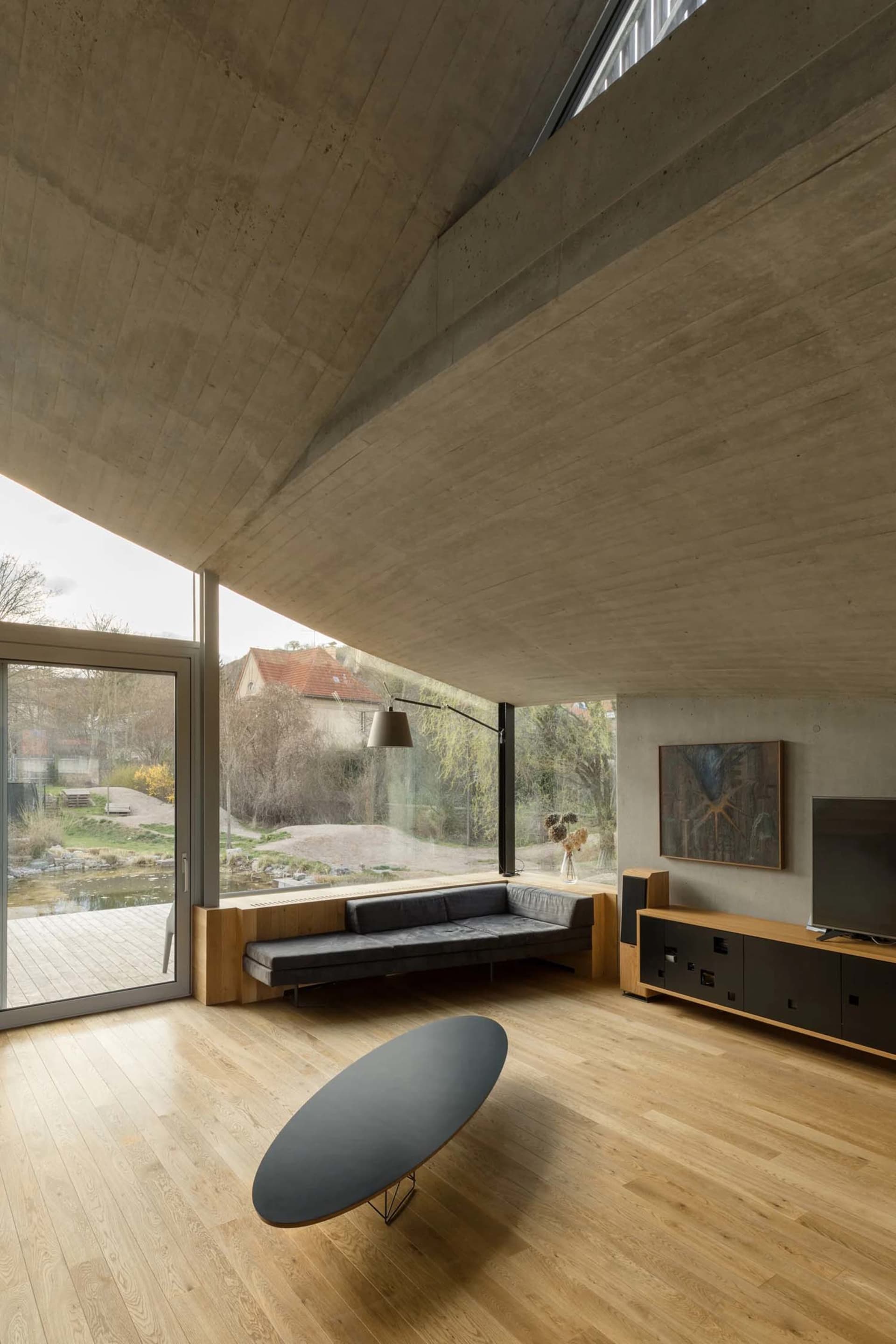 Modern living room featuring concrete, glass, and wooden elements