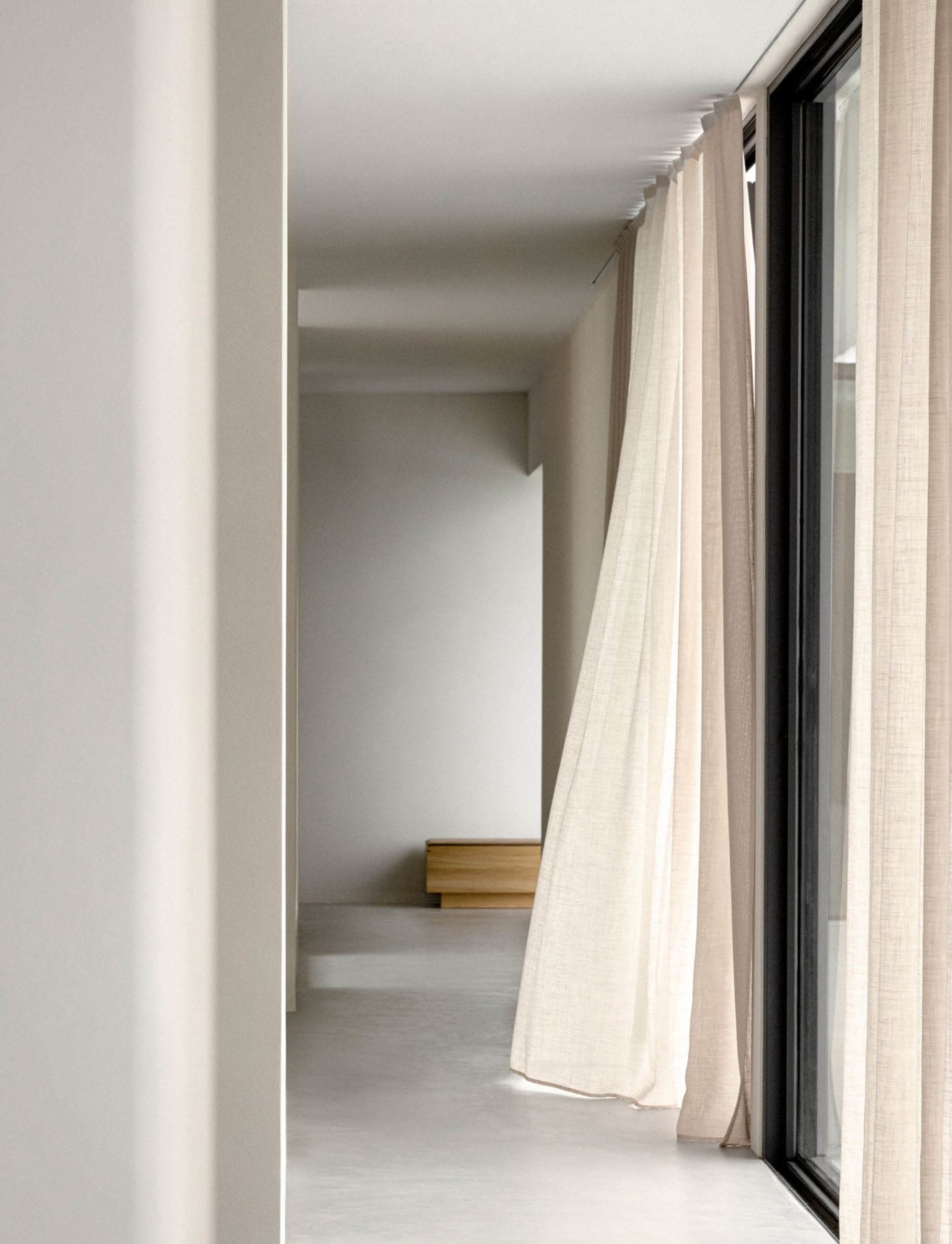 Lighting design in a modern room with minimalistic decor and fabric curtains.