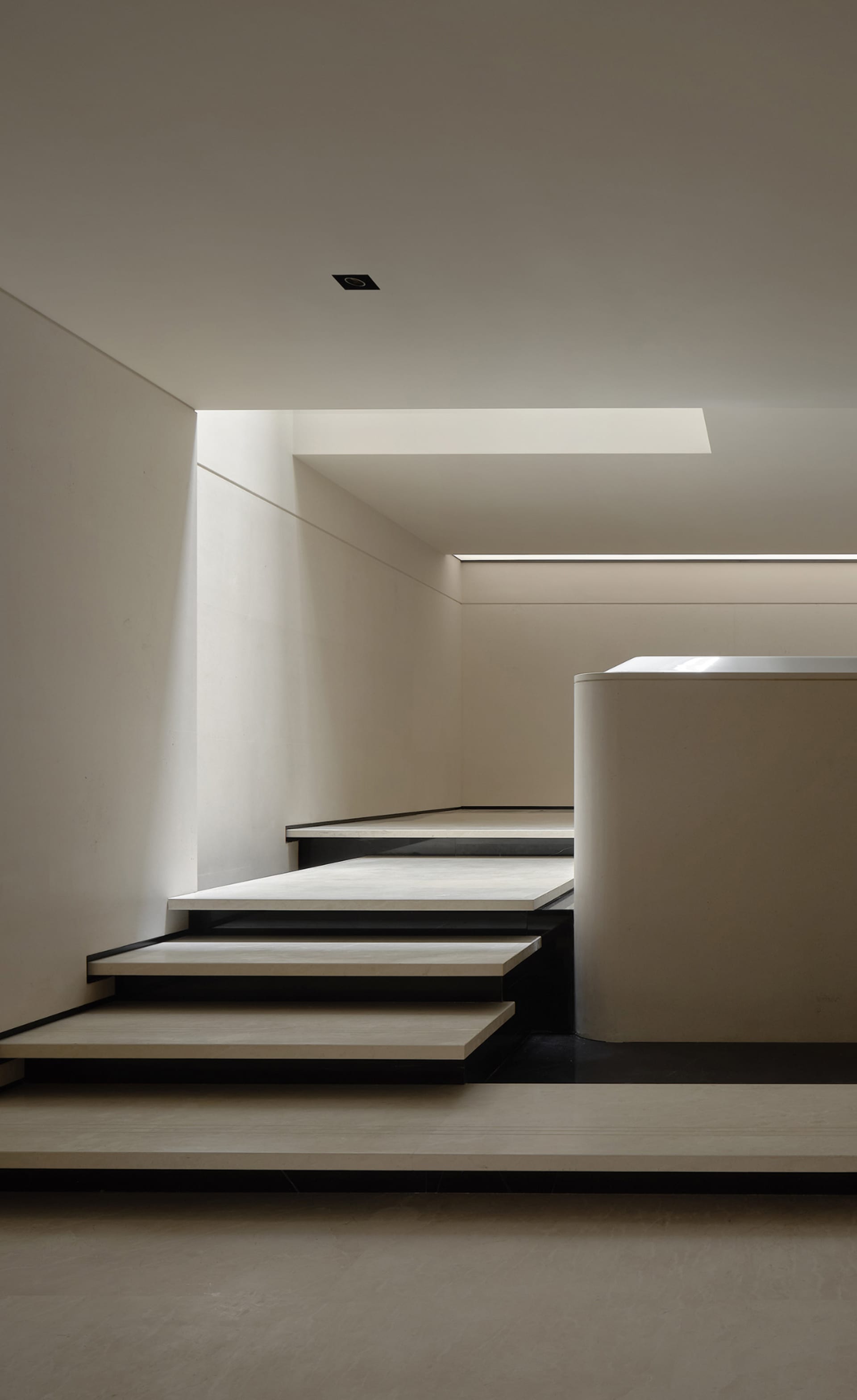 Modern staircase with concrete steps and white walls.