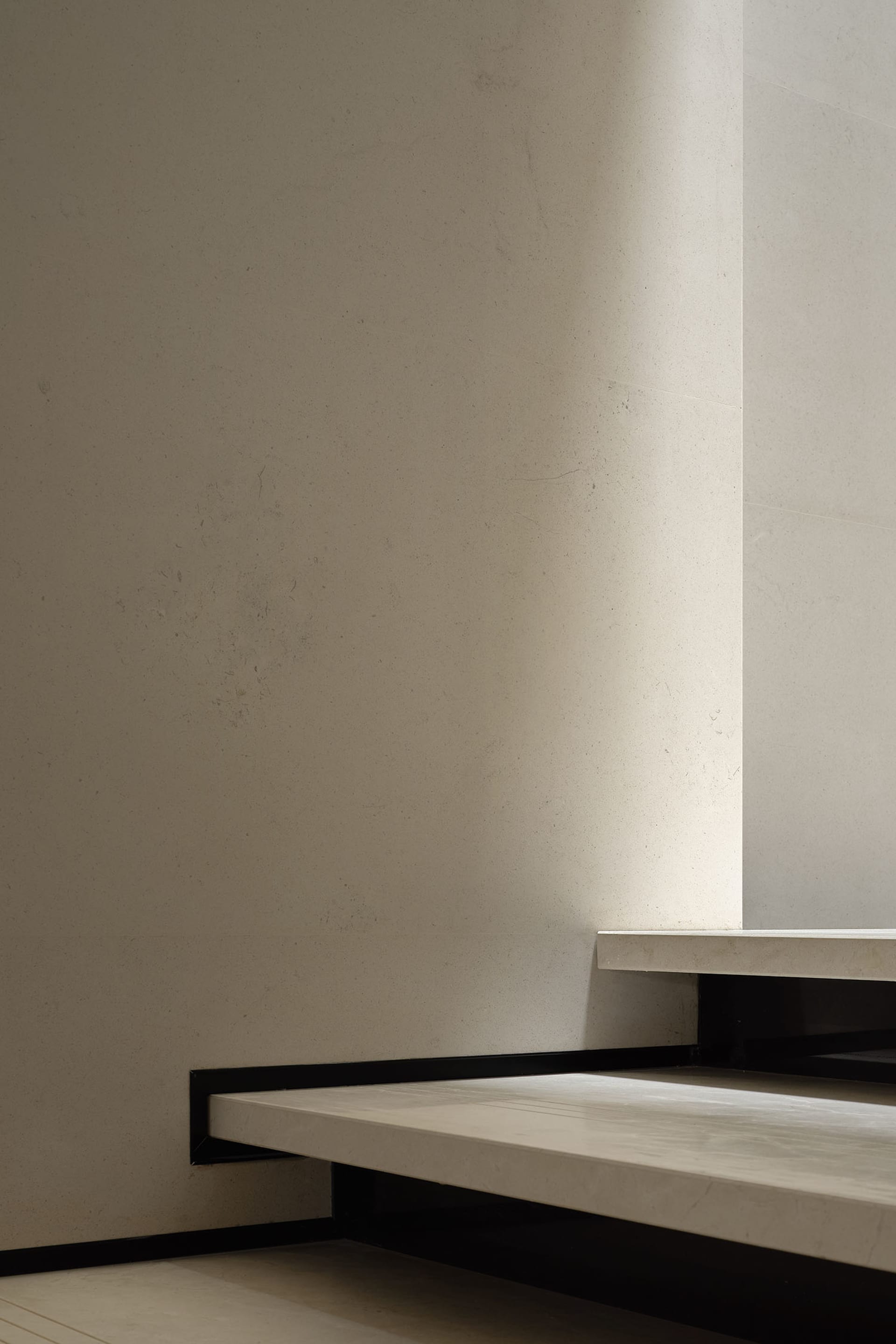 A minimalist, modern interior space with concrete flooring and walls.