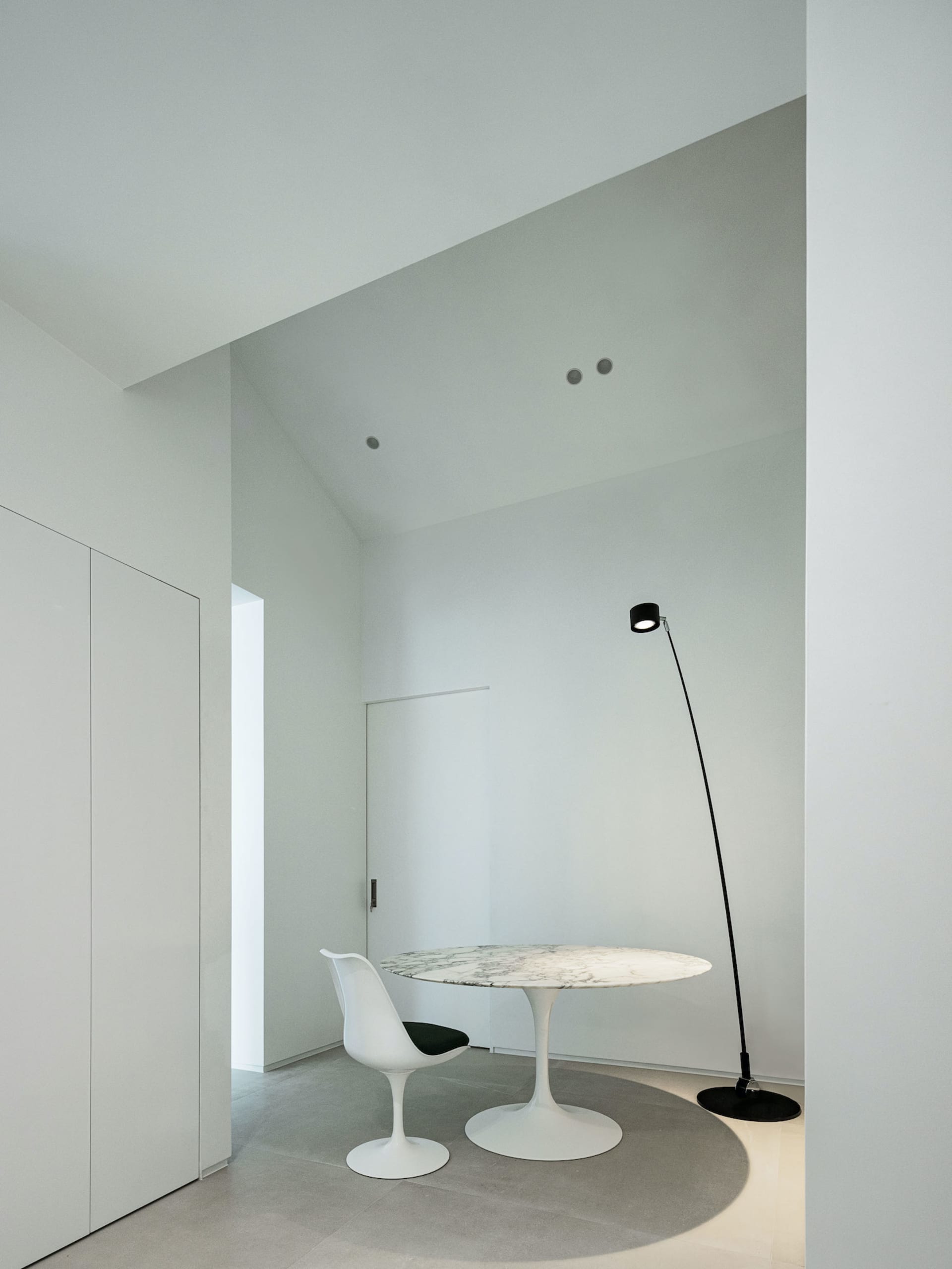 A minimalist study room with a modern marble table and a white chair.