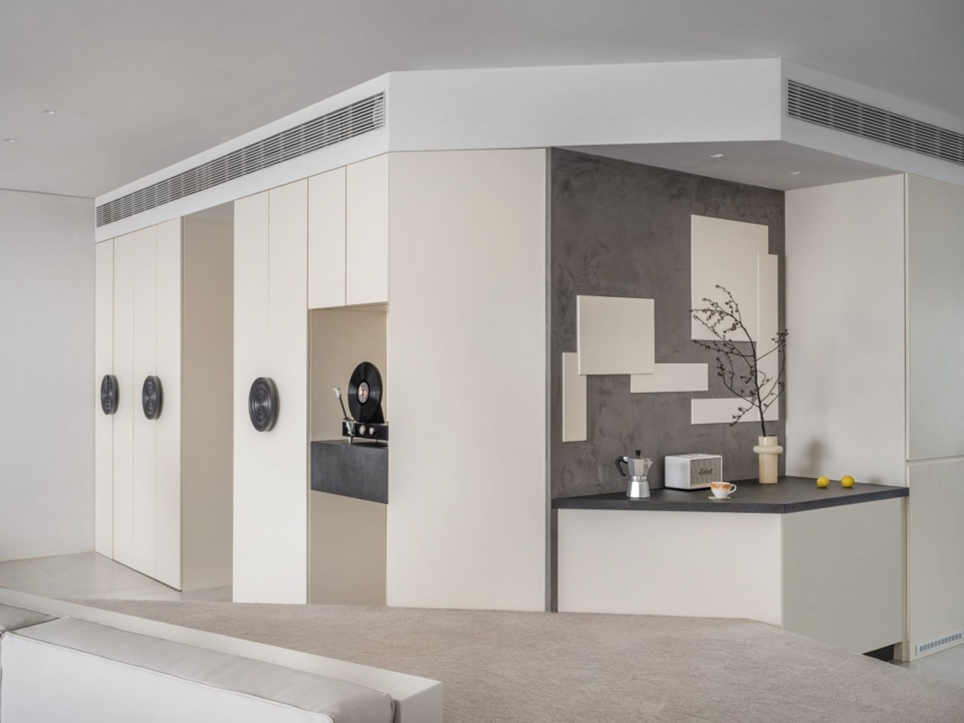 A minimalist kitchen with concrete walls and a black countertop.