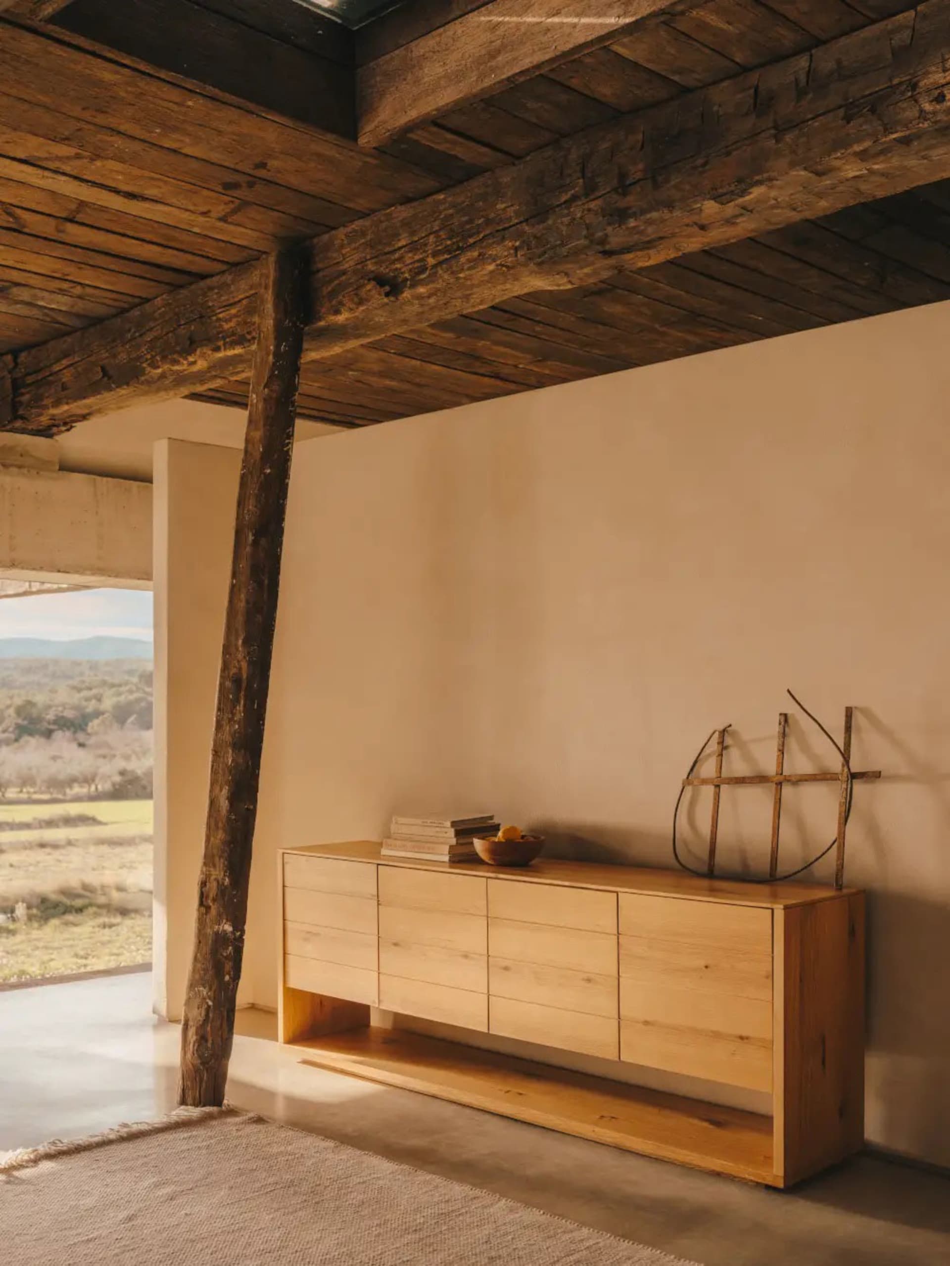 Minimalist living room designed in wood with a natural color palette.