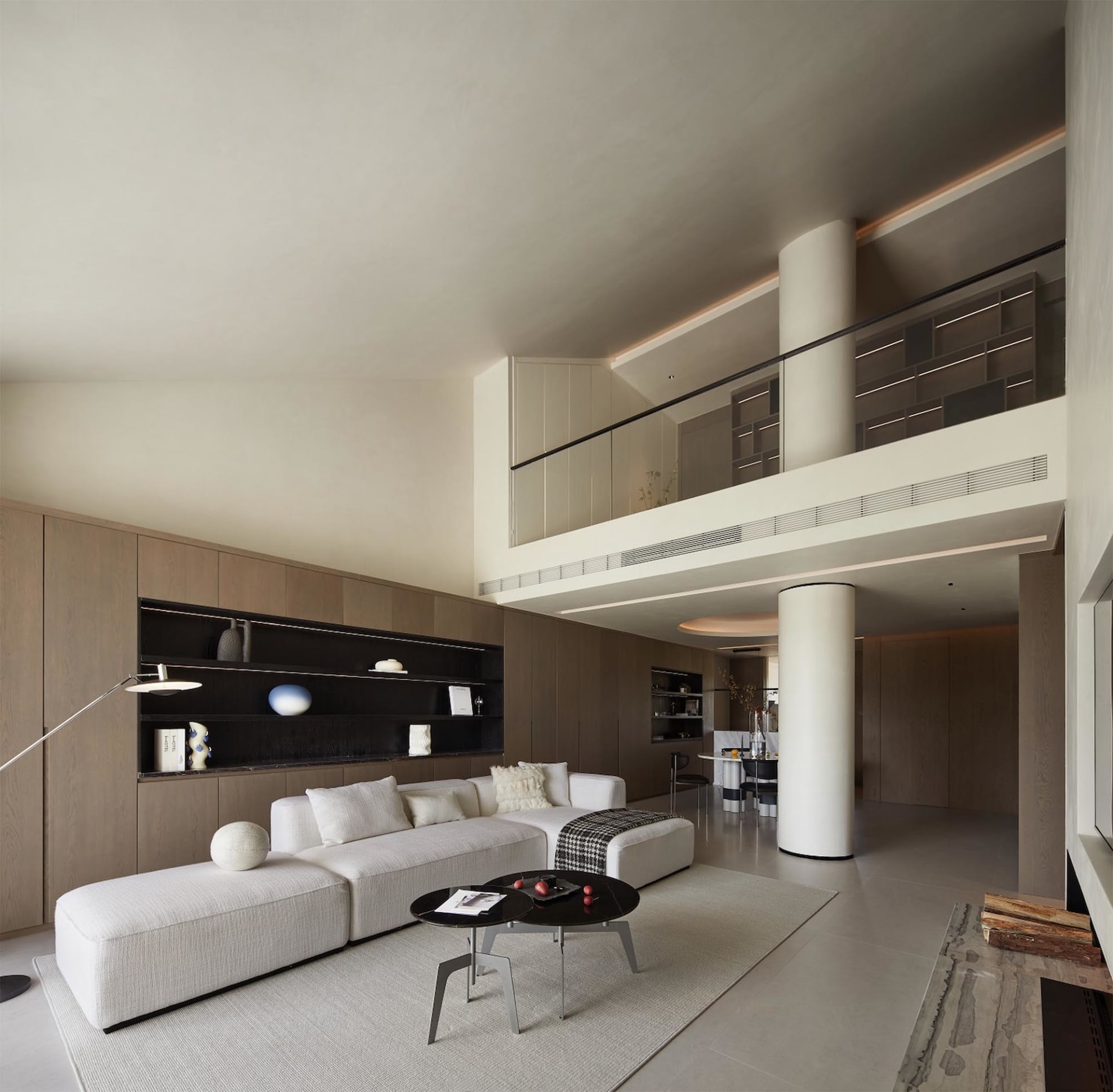 A minimalist living room featuring modern furniture, marble accents, and glass elements.