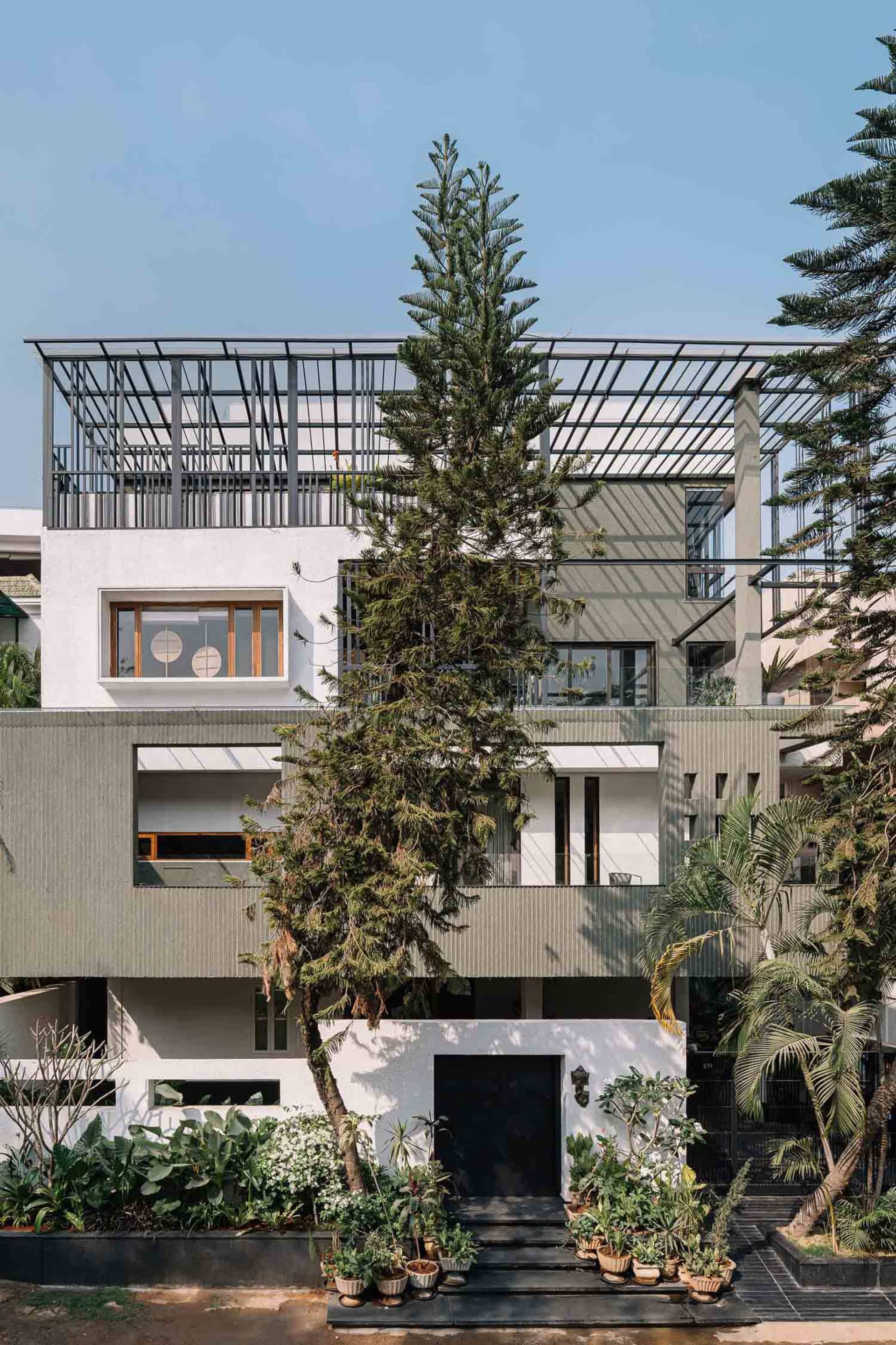 一座以混凝土建造的現代住宅涼亭,配有大型窗戶與涼棚。